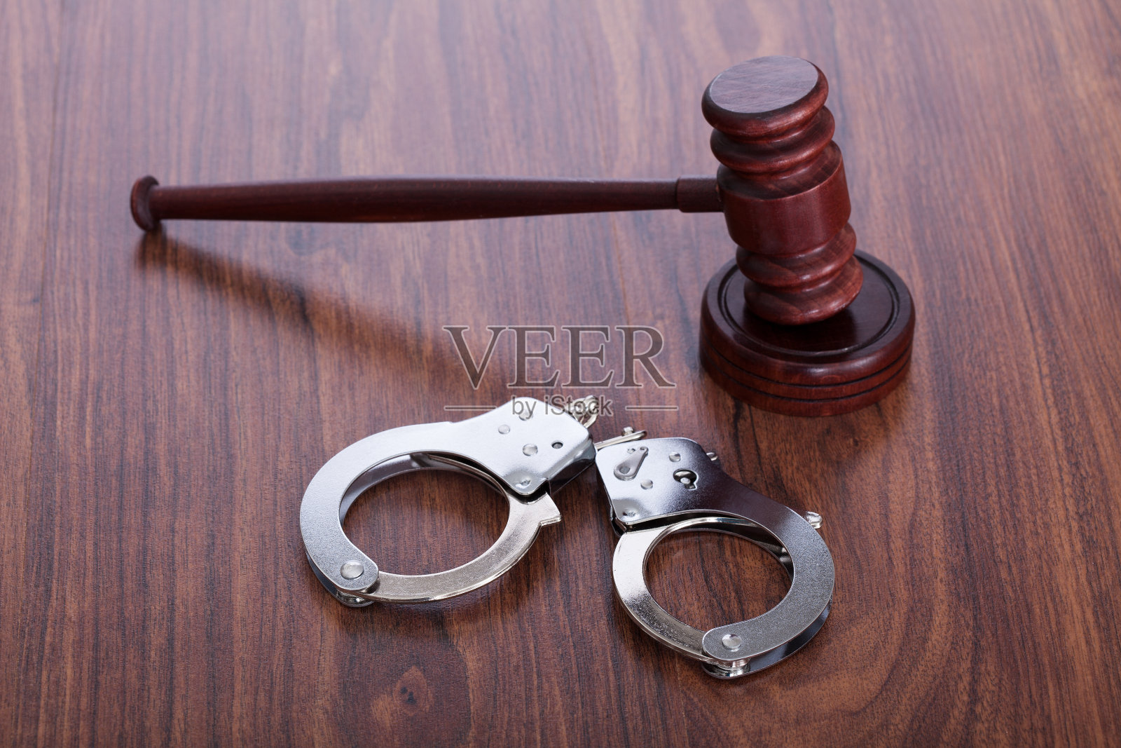 木桌上的木槌和手铐照片摄影图片
