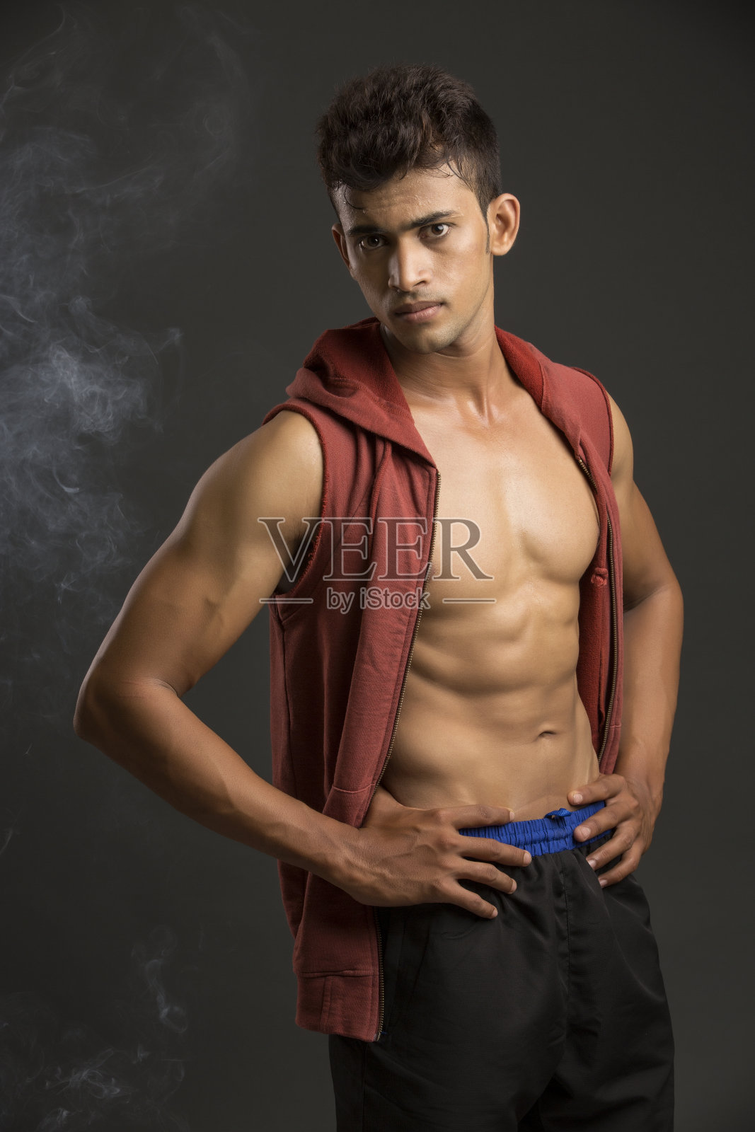 帅气的运动员摆姿势与开放的夹克在烟雾效果照片摄影图片