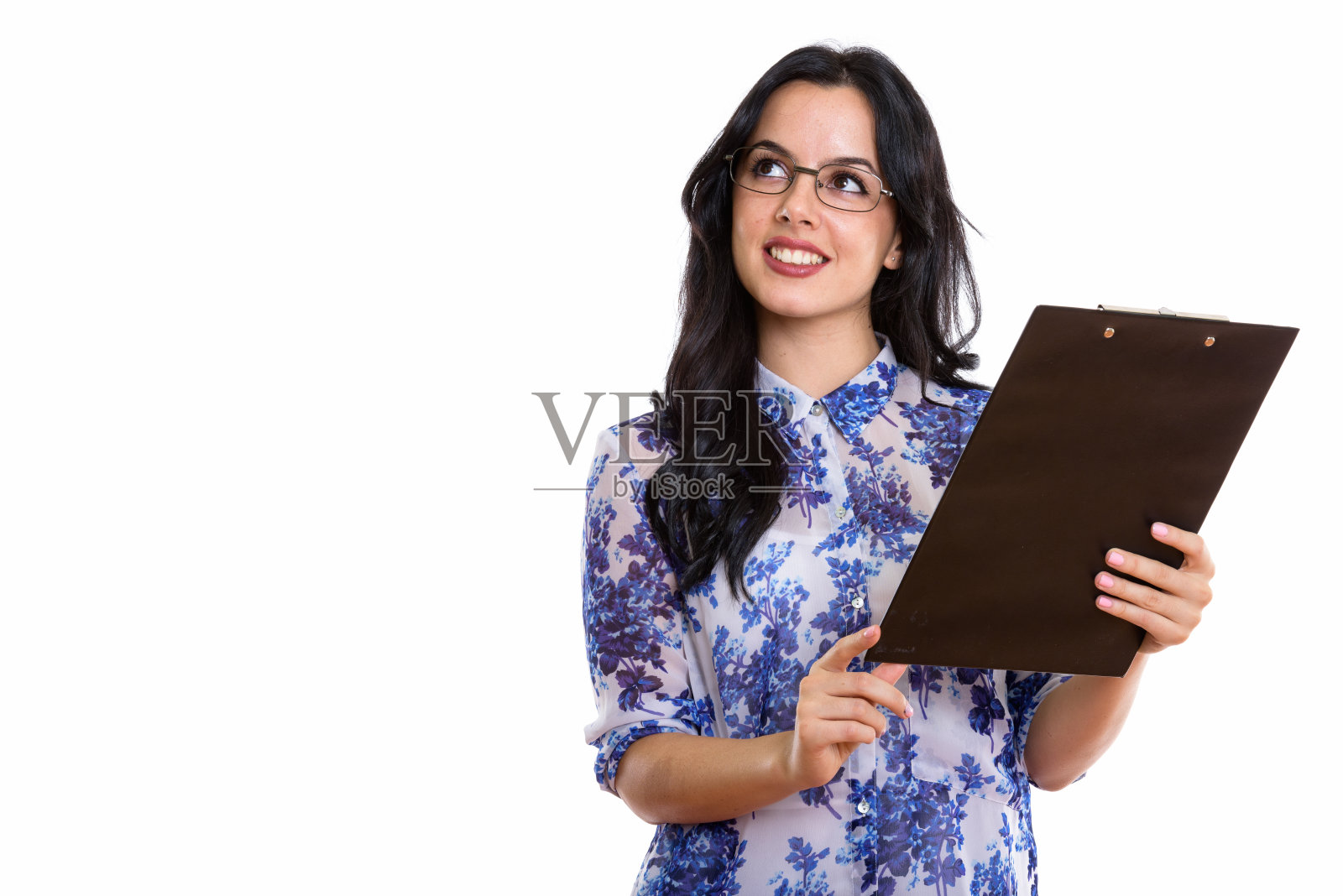 工作室拍摄的年轻快乐的西班牙女商人微笑着拿着剪贴板思考照片摄影图片