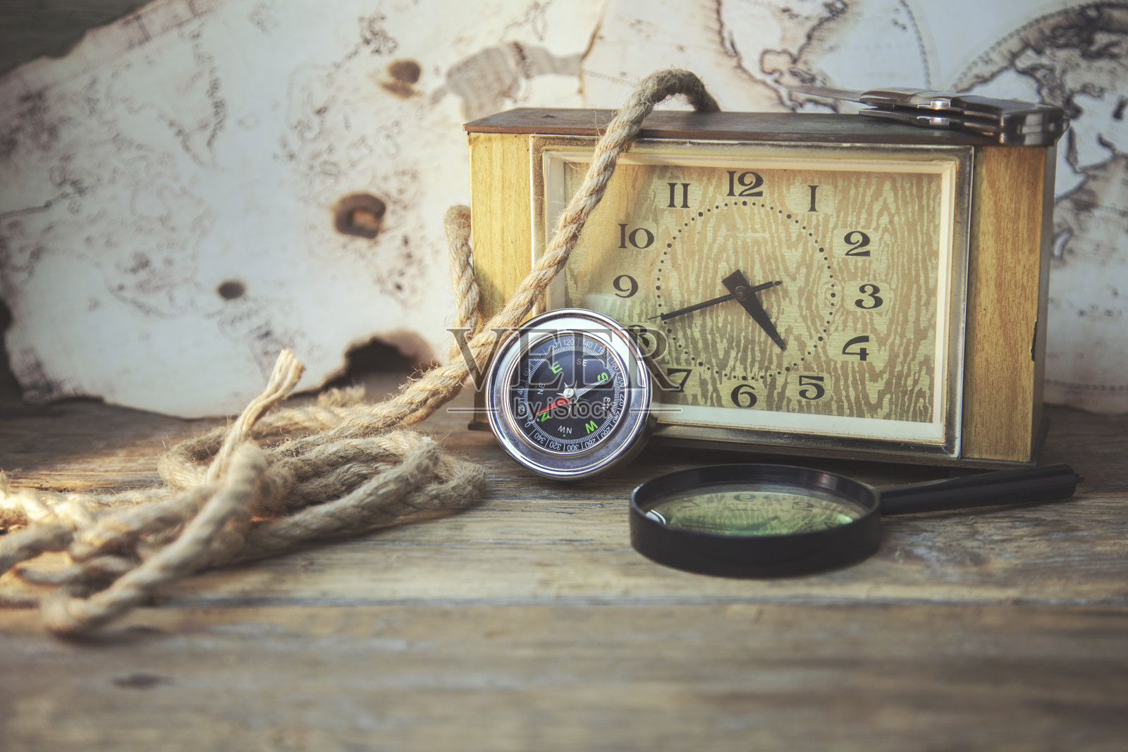 钟表，放大镜，指南针和地图放在木桌上照片摄影图片