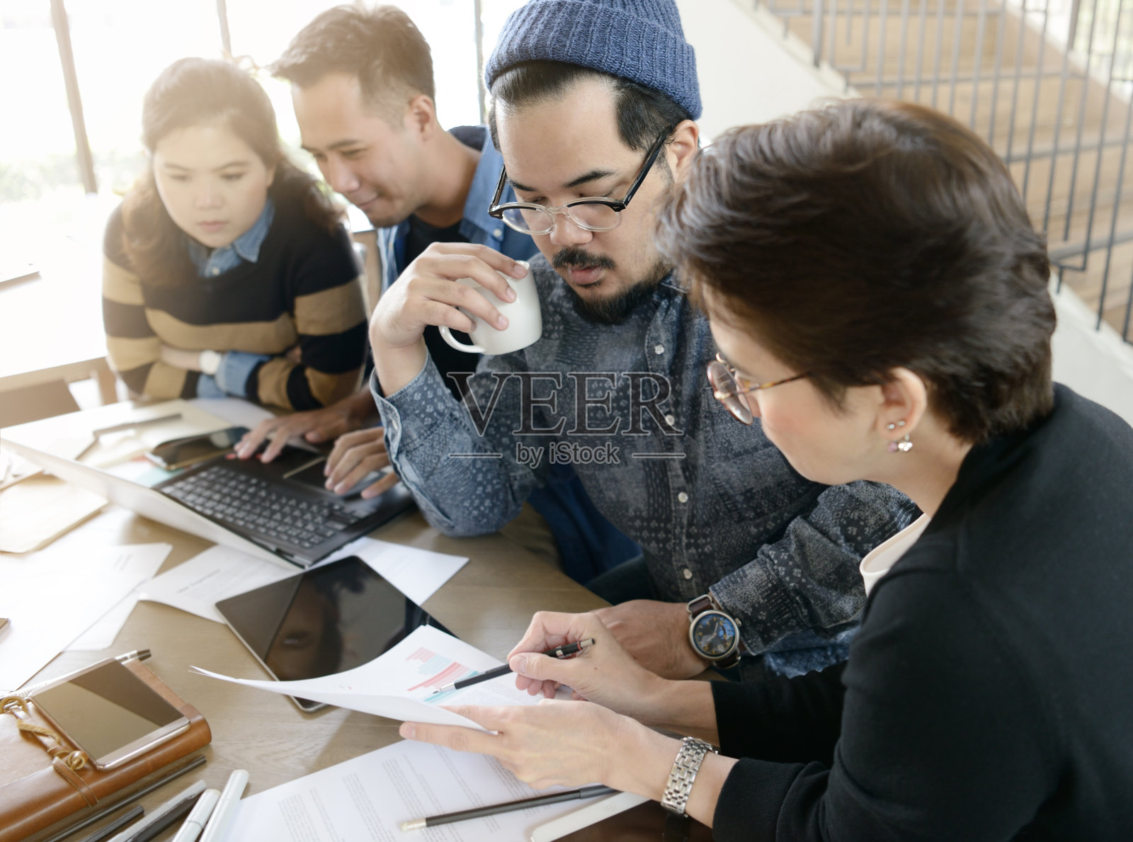 不同年龄的创意商业人士在咖啡厅讨论工作照片摄影图片