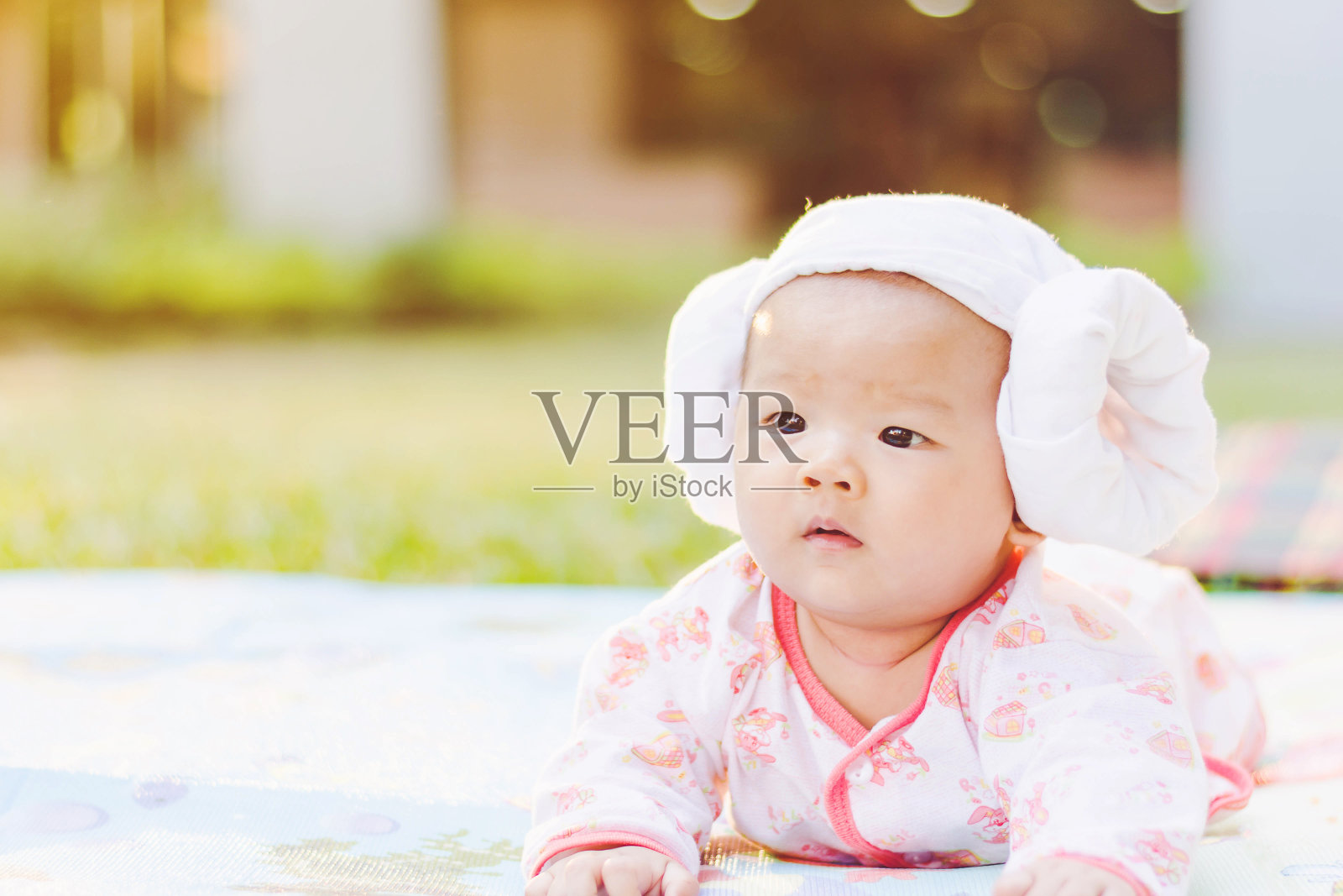 可爱的宝宝趴在公园的地上照片摄影图片