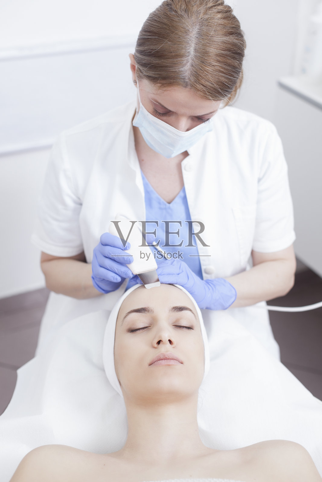 年轻漂亮的女子在美容院做面部护理照片摄影图片