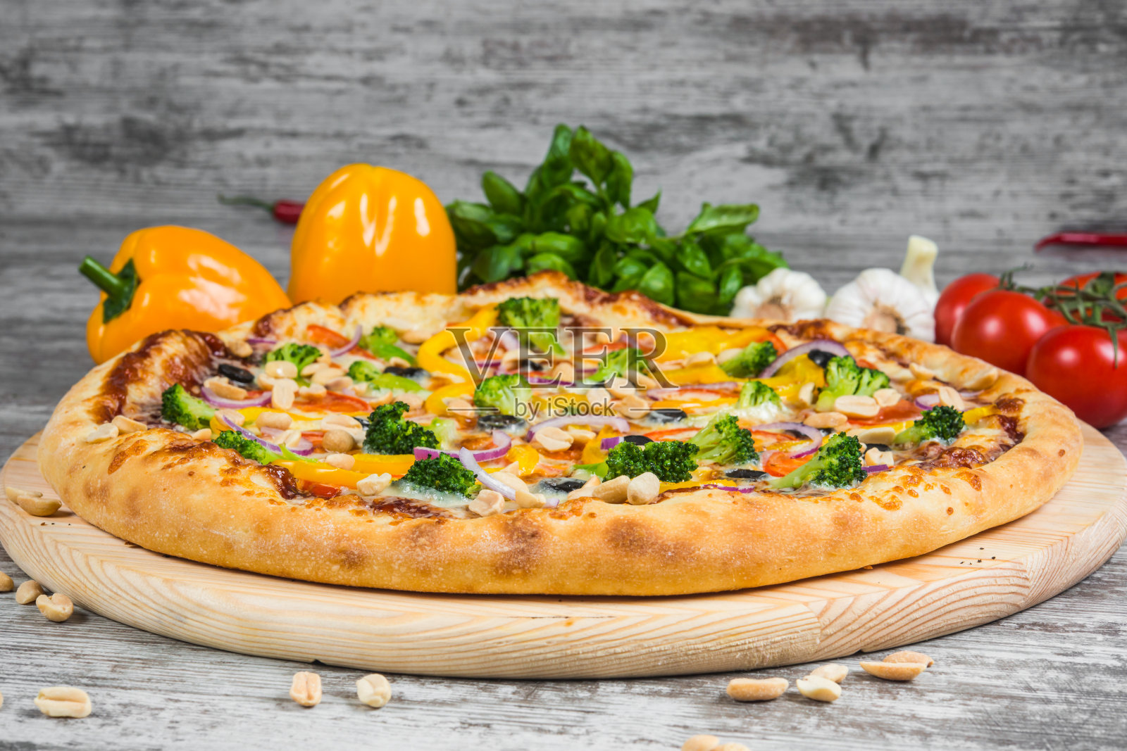 有迷迭香和香料的素食披萨，在浅色的木制背景上。以绿色罗勒和新鲜蔬菜为背景的意大利披萨照片摄影图片