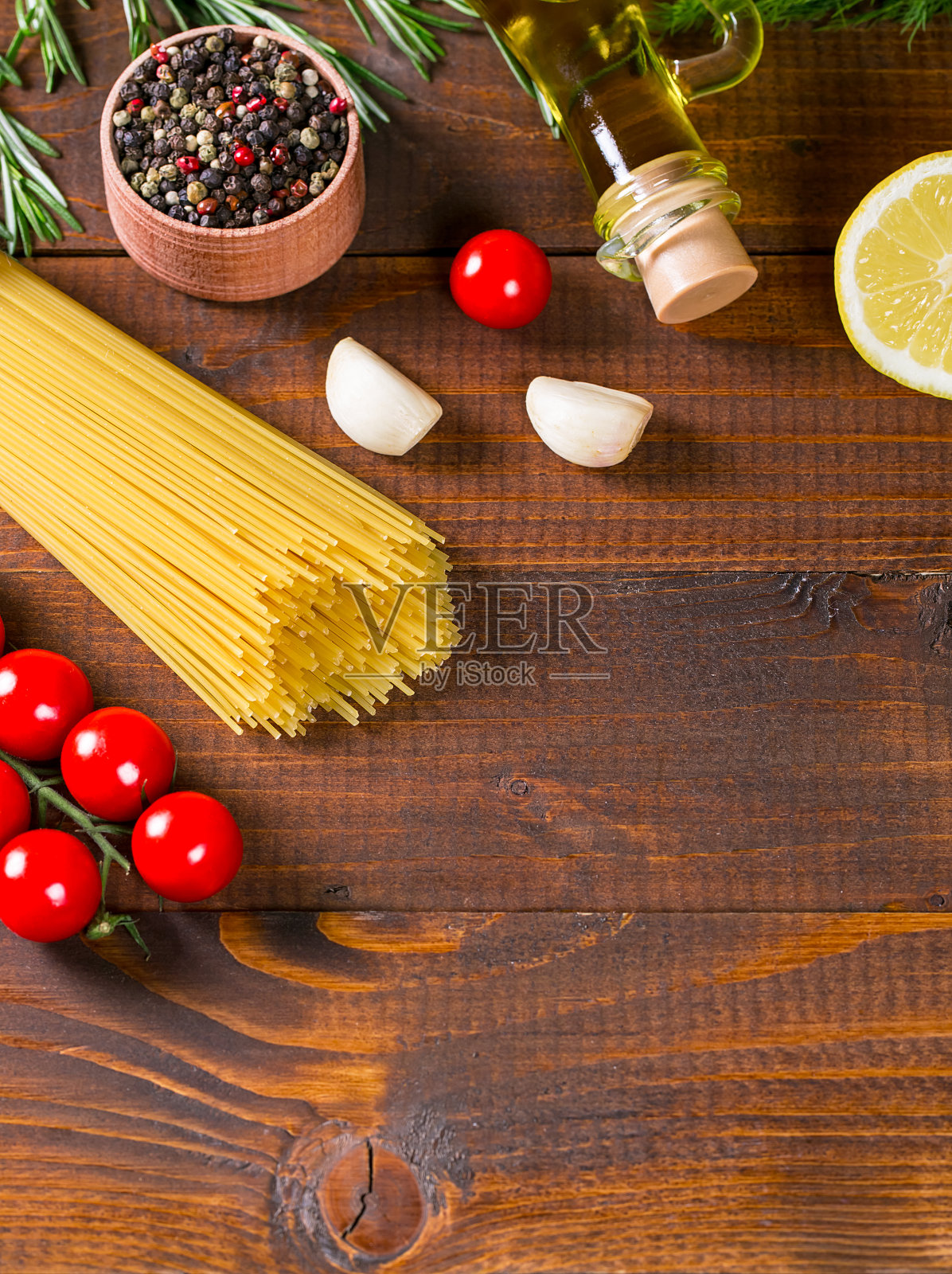 意大利面，西红柿，樱桃，橄榄油，香草和香料在旧的棕色木制背景。照片摄影图片