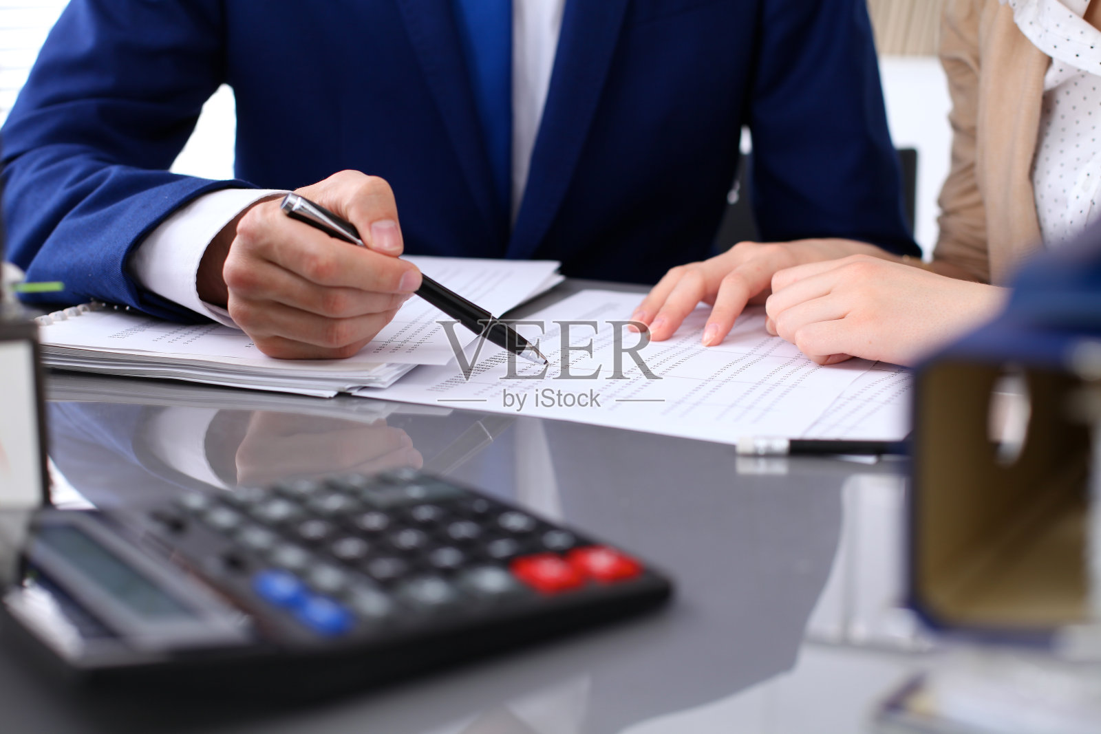 簿记员或财务稽核员及秘书作报告，计算或核对余额。美国国税局稽查员检查财务文件。审计概念。照片摄影图片