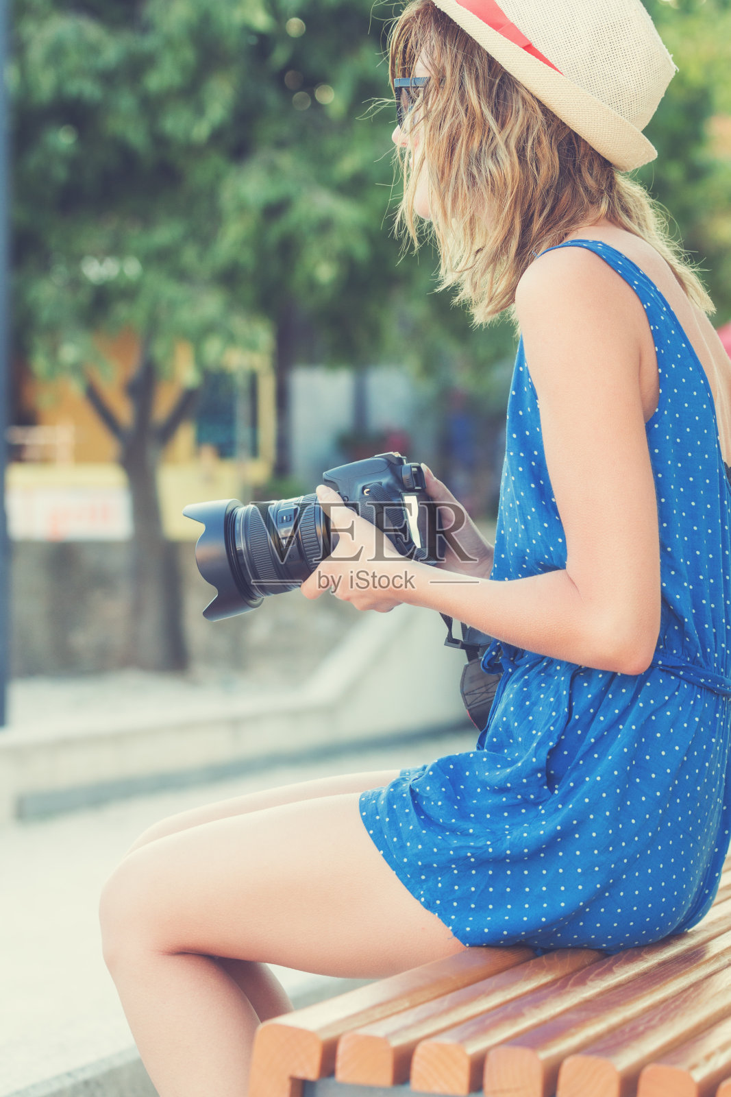 年轻的都市女孩拿着相机走在街上。照片摄影图片