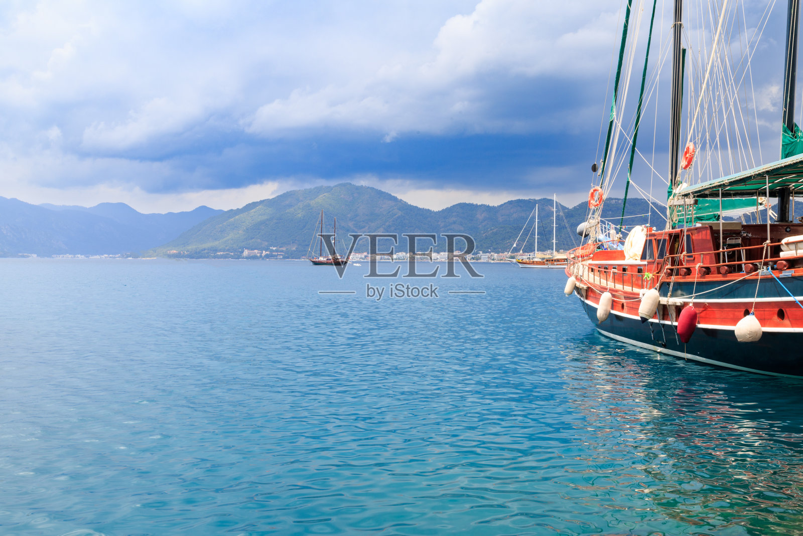 在马尔马里斯海港的小船，云中有山照片摄影图片