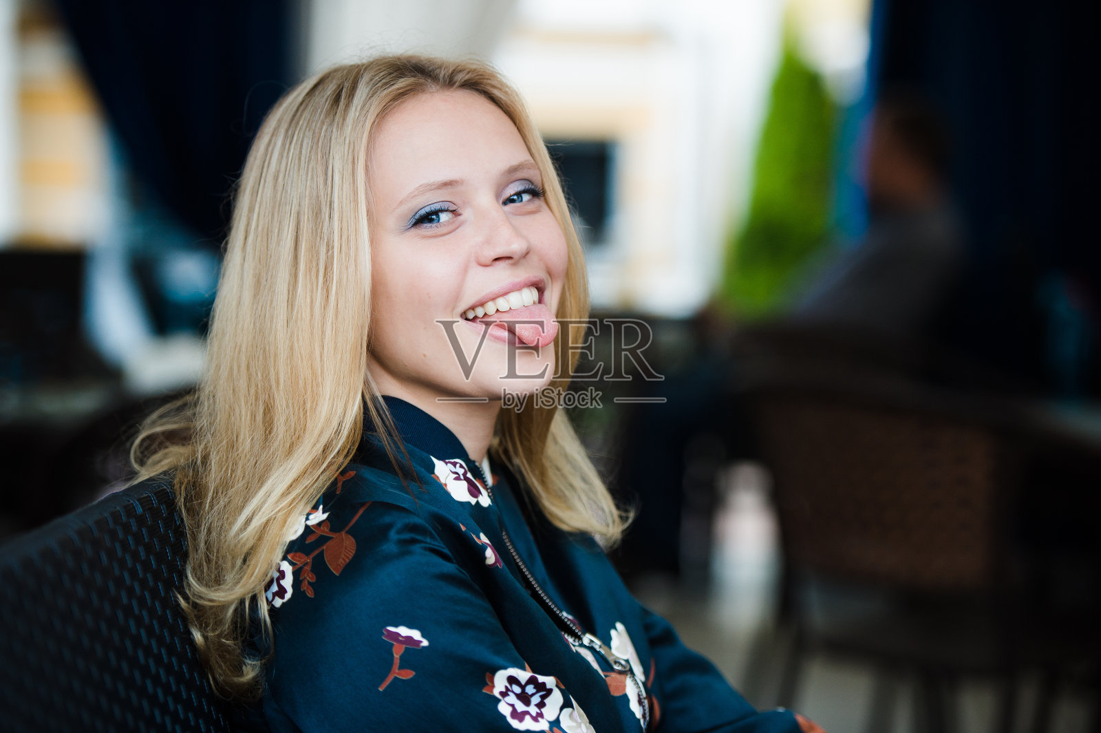 漂亮的金发女孩露出舌头，看着照片摄影图片