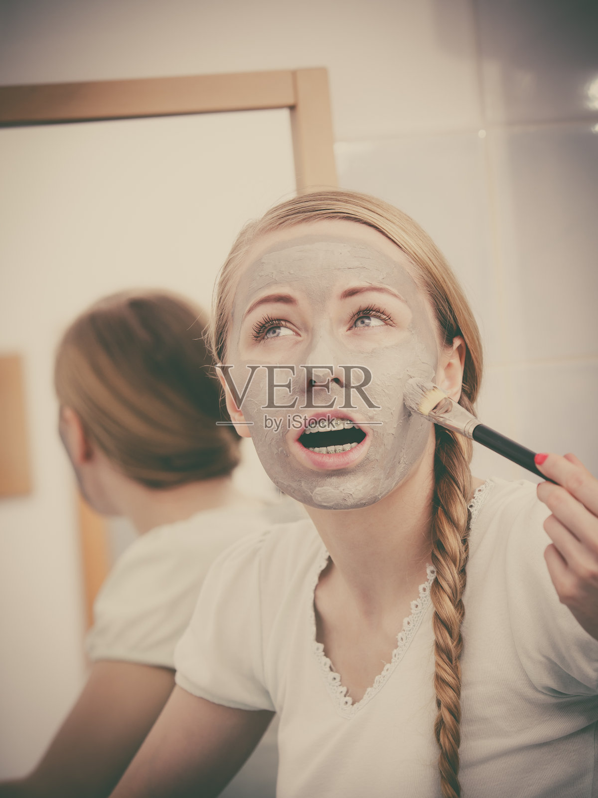 脸上戴着灰色泥面膜的女人照片摄影图片