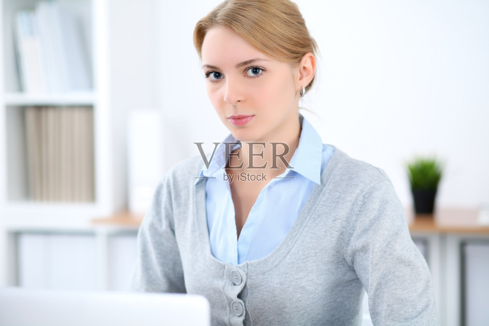 年轻的金发女商人，办公室里有笔记本电脑。经营理念照片摄影图片