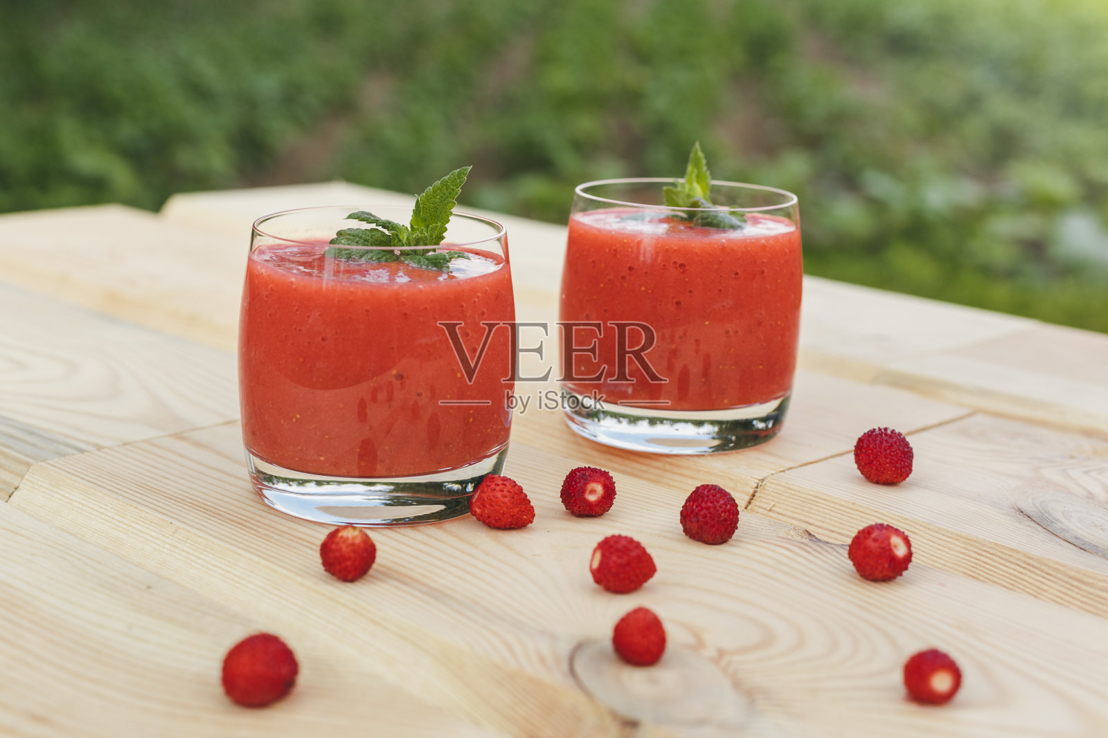 木桌上放着一杯薄荷草莓奶昔照片摄影图片