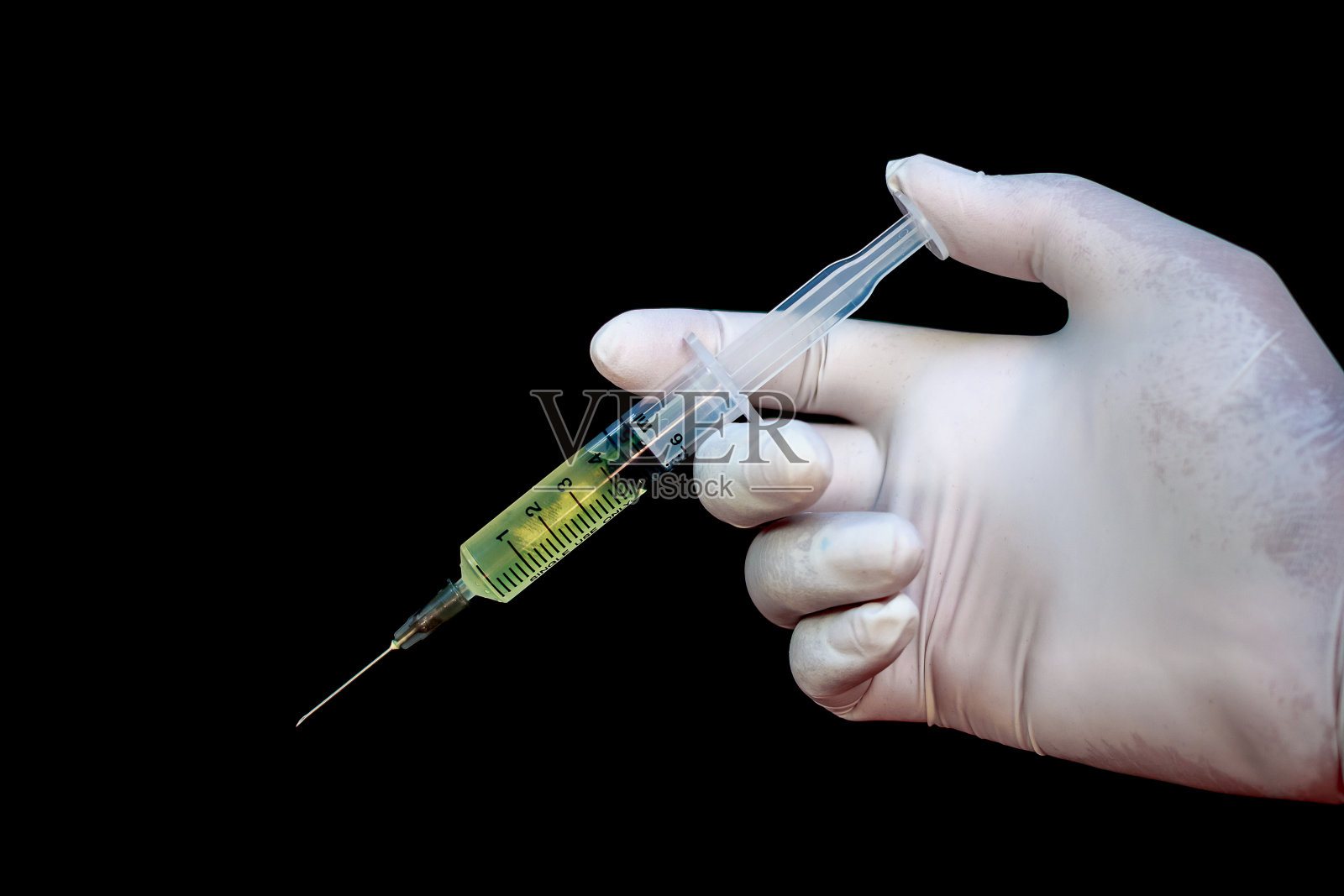 注射器在手上的医疗手套，准备注射与药物。黑色背景照片摄影图片