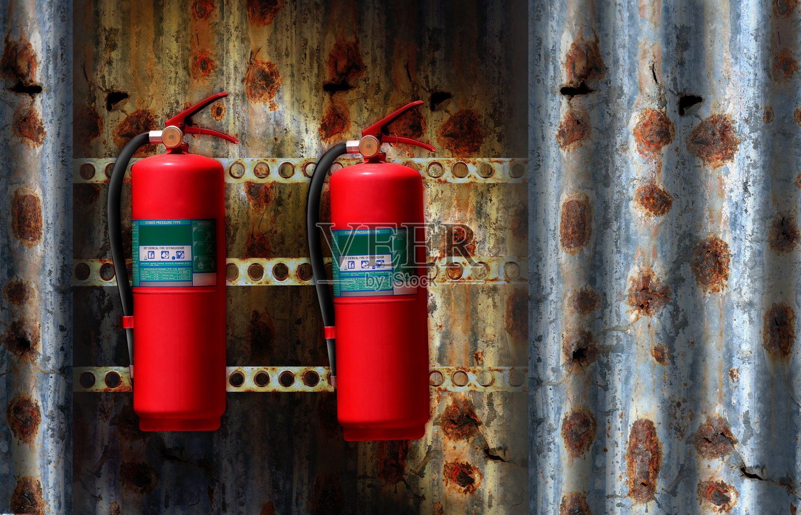 垃圾钢墙上的红色灭火器水箱照片摄影图片