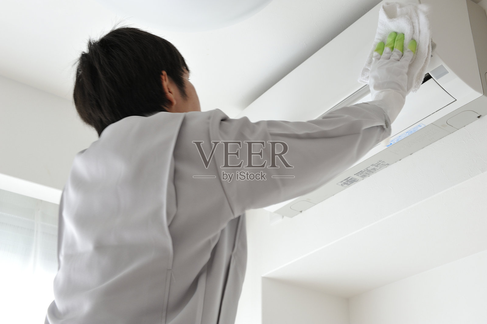 一名日本男子穿着工作服去清洁空调照片摄影图片