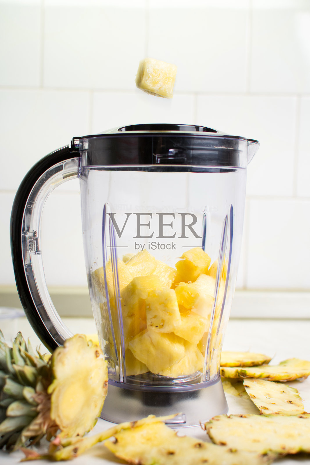 菠萝片落入搅拌机照片摄影图片