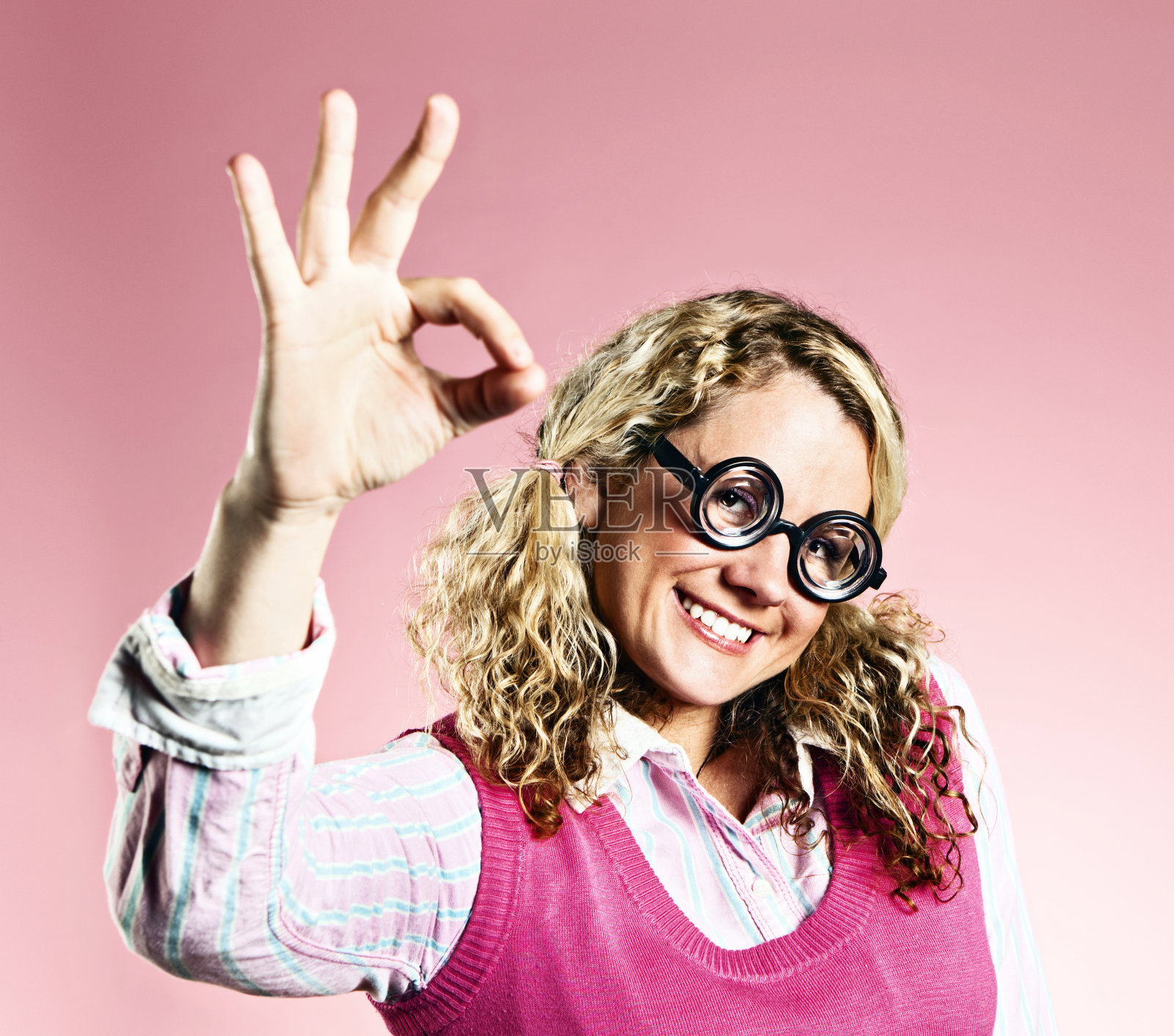 可爱的微笑金发书呆子做出OK手势照片摄影图片