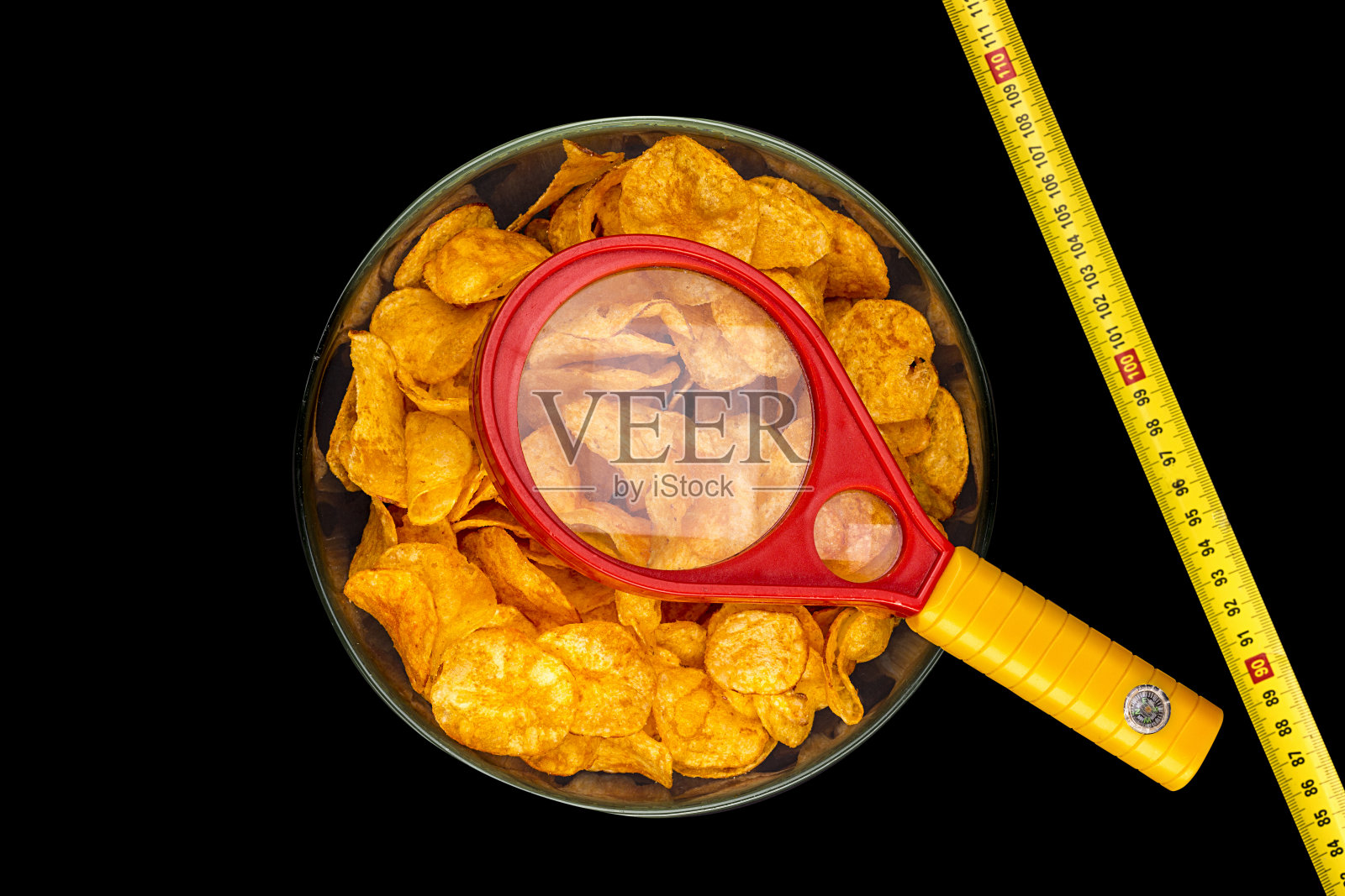 一碗用放大镜和测光尺测量的薯片照片摄影图片