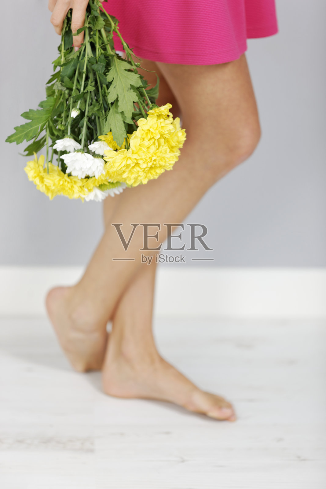 女人的腿旁放着鲜花照片摄影图片