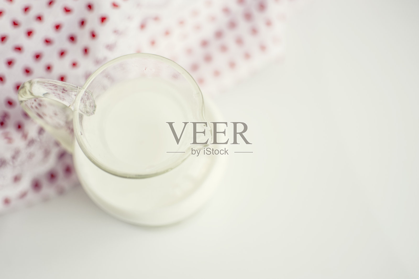 白色表面上放着牛奶的玻璃罐照片摄影图片