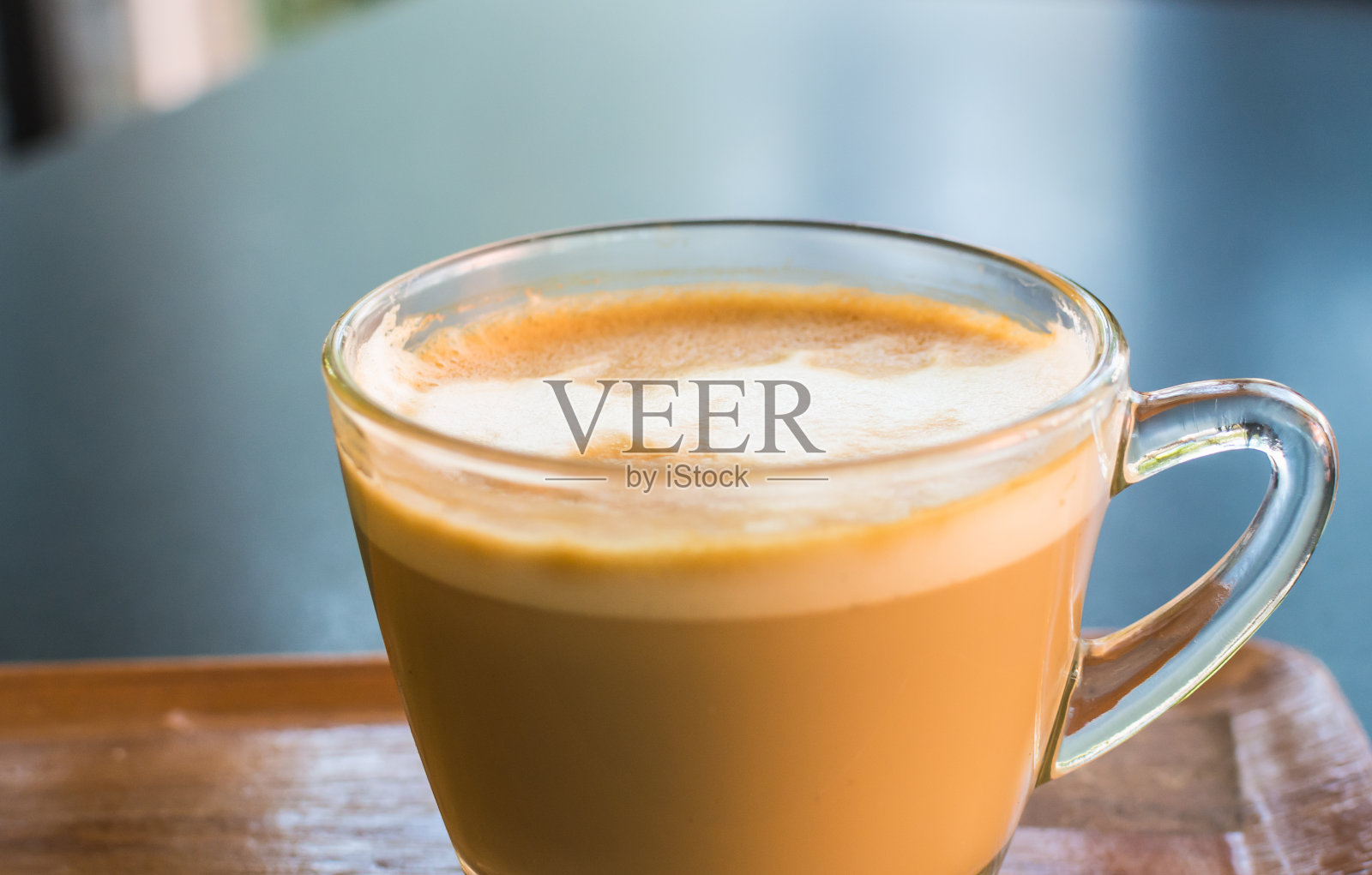 卡布奇诺或拿铁咖啡在一个透明的玻璃马克杯。照片摄影图片