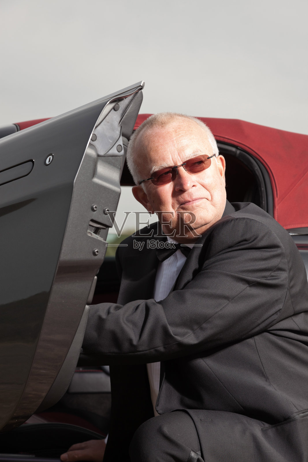 帅气的退休老人开着他的跑车。照片摄影图片