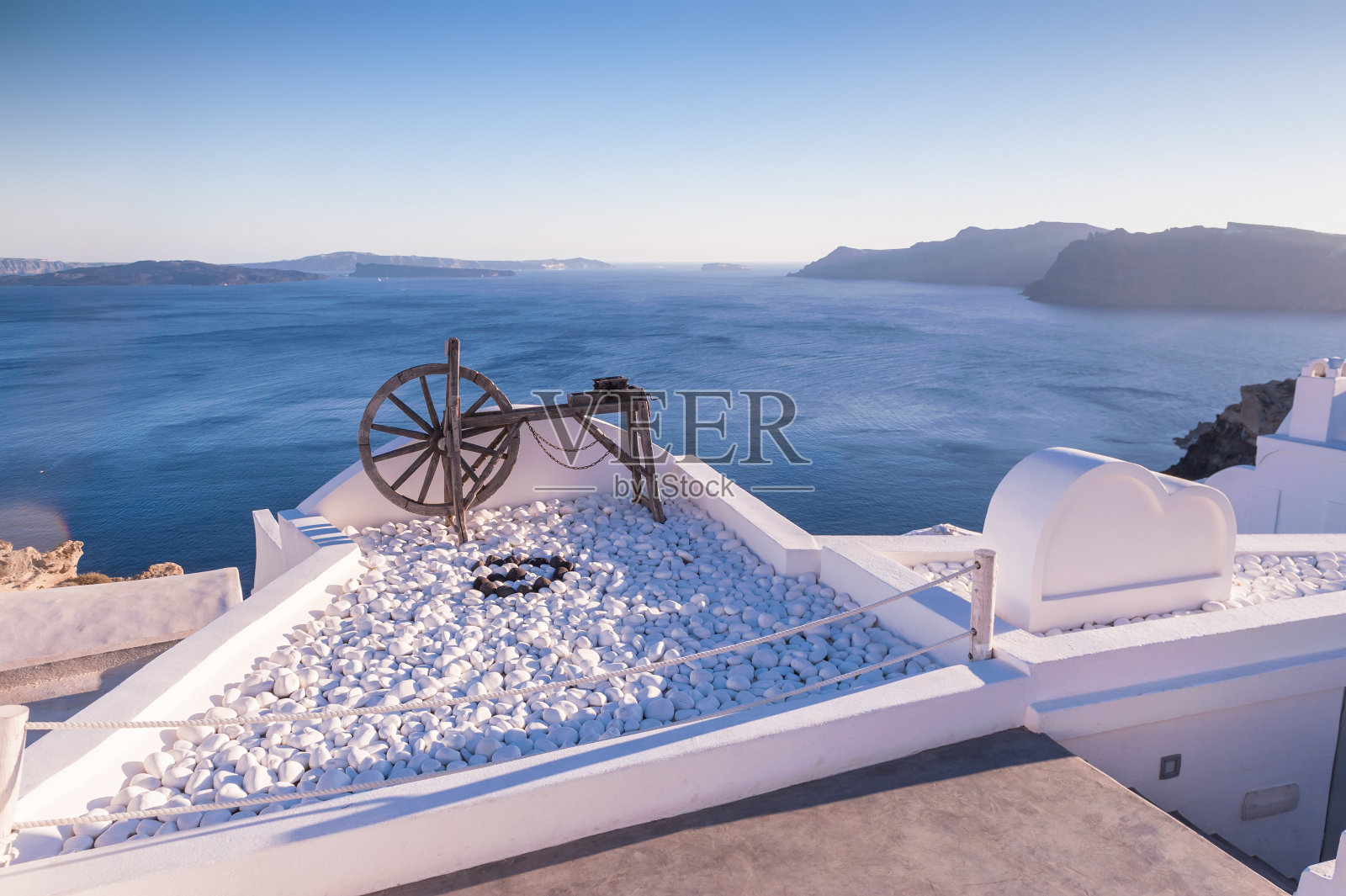 伊亚市屋顶上的老式木制水泵轮照片摄影图片