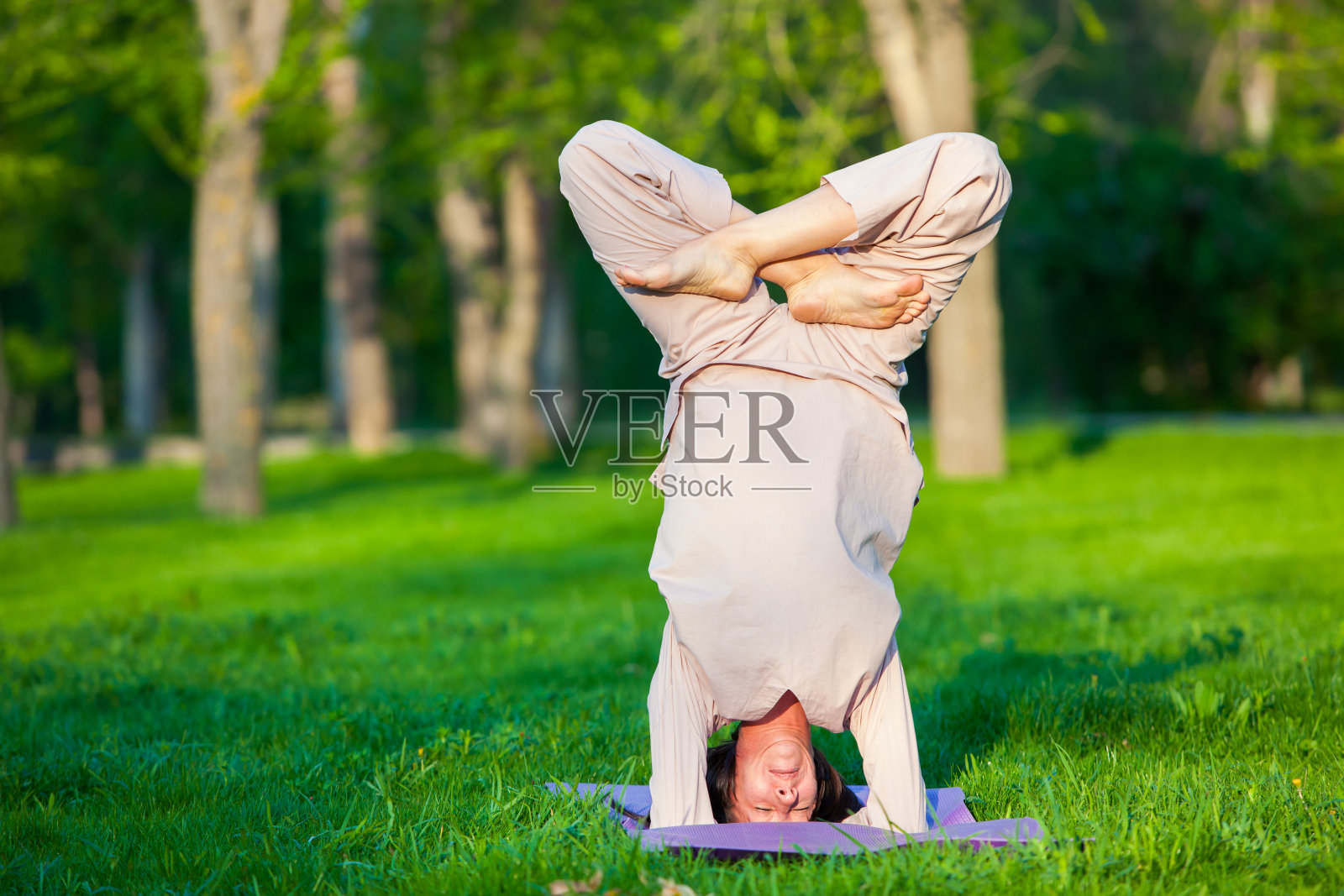 早上在树的背景下练习瑜伽照片摄影图片