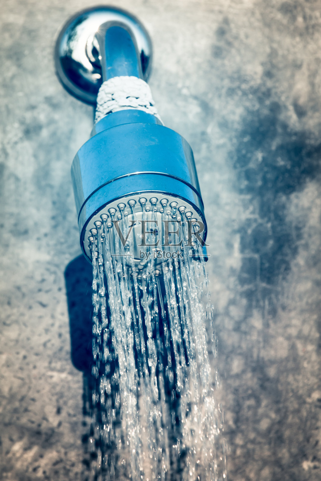 在水泥背景上以蓝色调滴水淋浴照片摄影图片