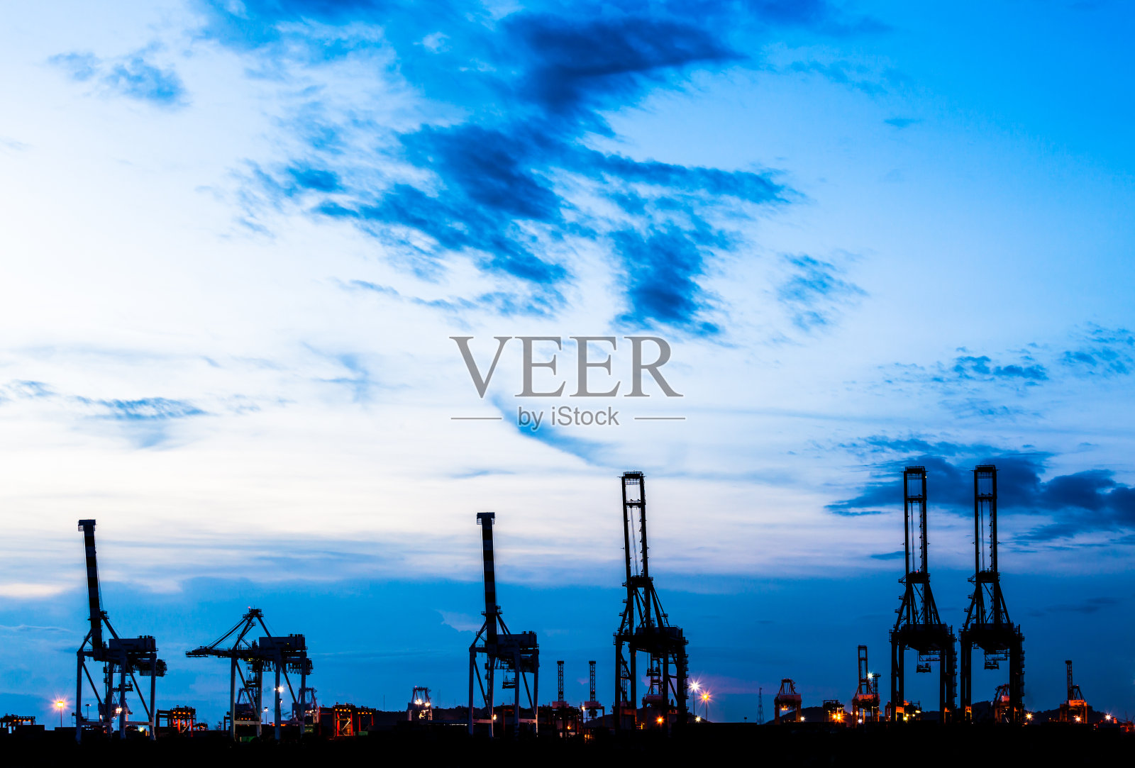 湛蓝的天空下，贸易港口的起重机照片摄影图片