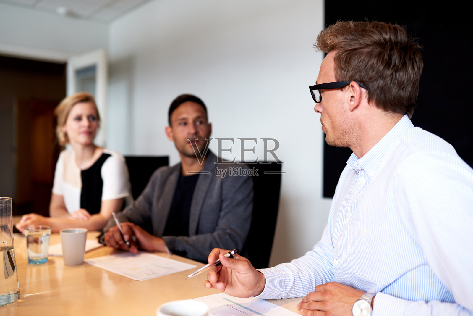 年轻的高管们在会议中面对面照片摄影图片