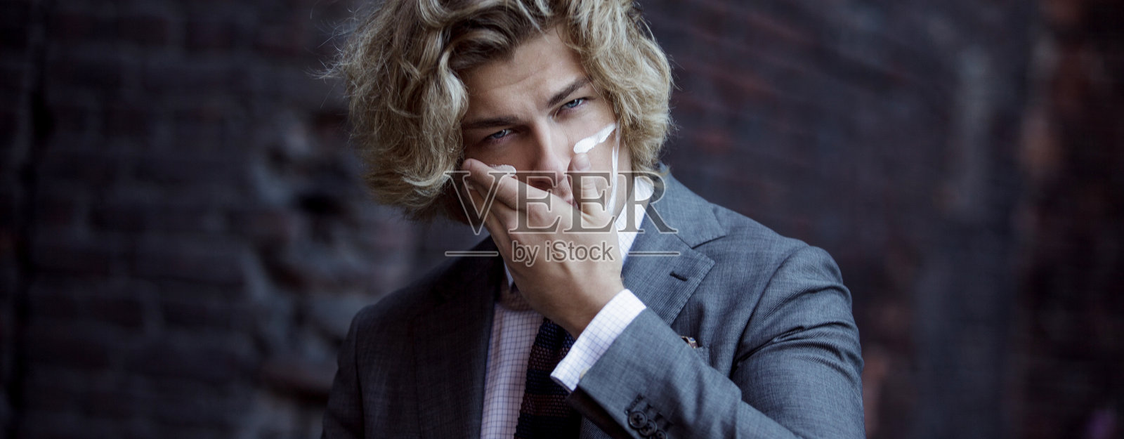 商人的战士。年轻人在脸上涂上了战争颜料照片摄影图片