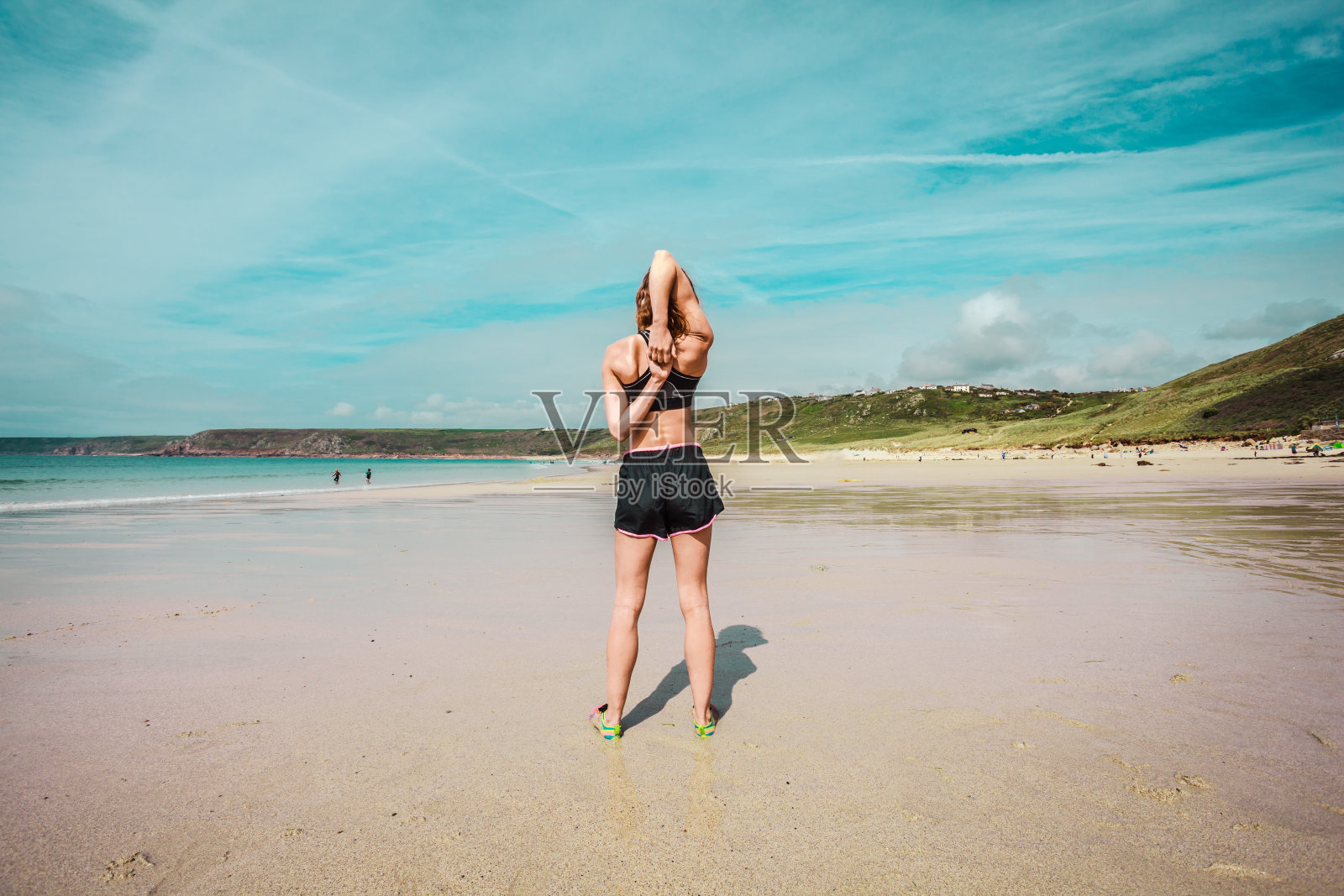 健康的年轻女子在海滩上伸展身体照片摄影图片