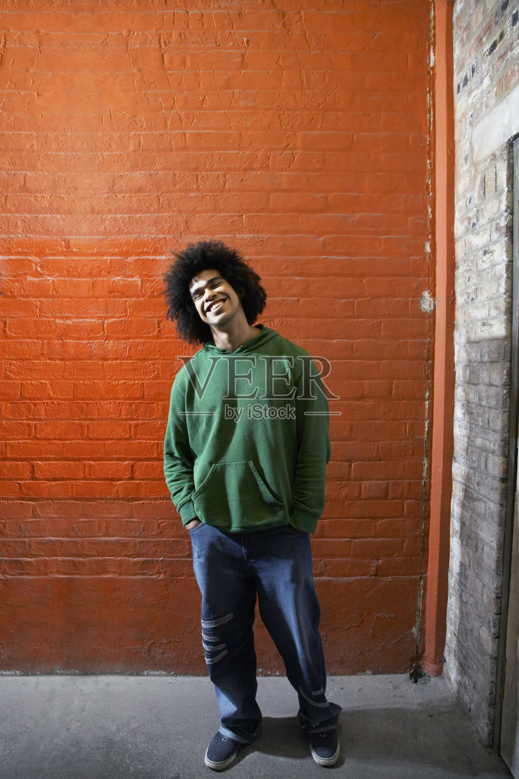 砖墙前微笑的男人照片摄影图片