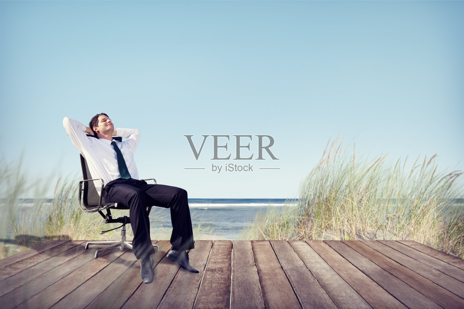 商人在海滩的办公椅上休息照片摄影图片