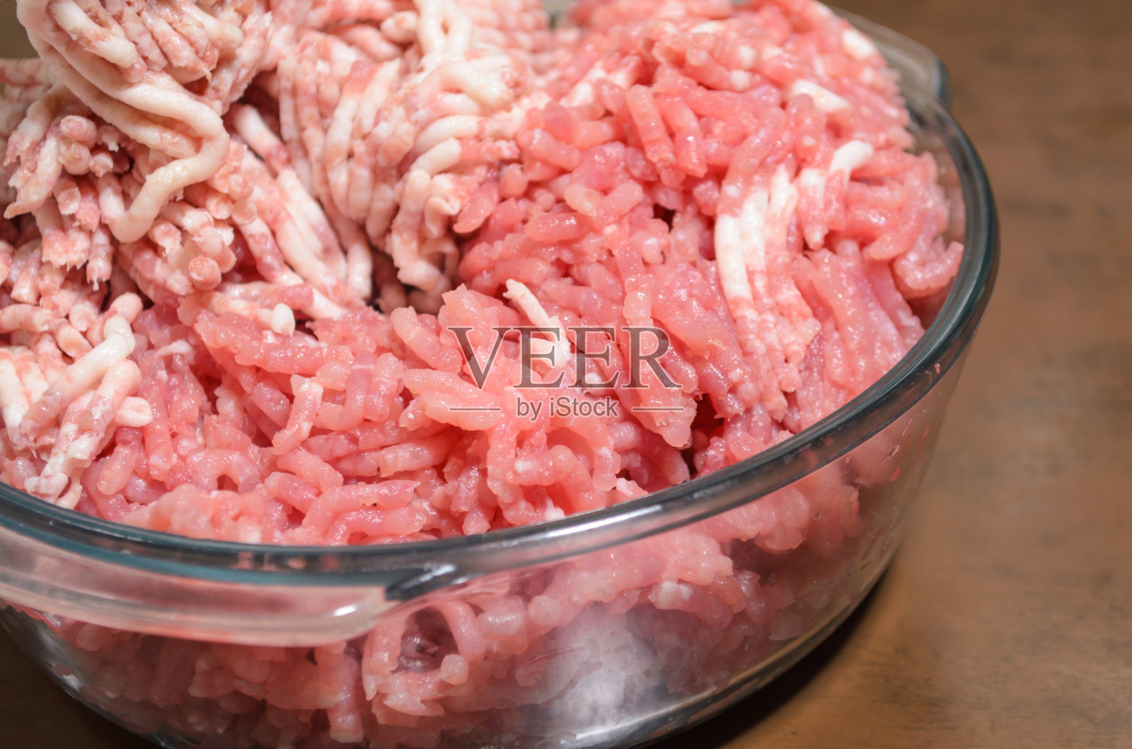 碎肉放在玻璃碗里放在木板上照片摄影图片