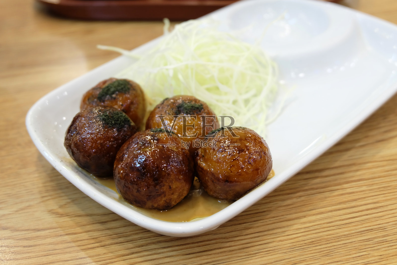 白盘子里的章鱼烧照片摄影图片