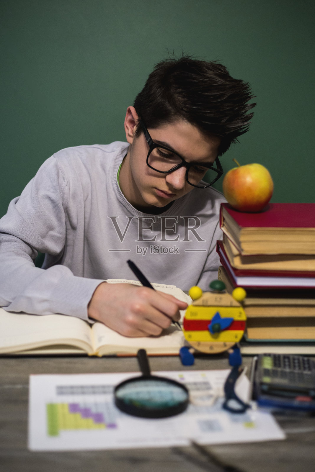 男孩在书桌上做作业照片摄影图片