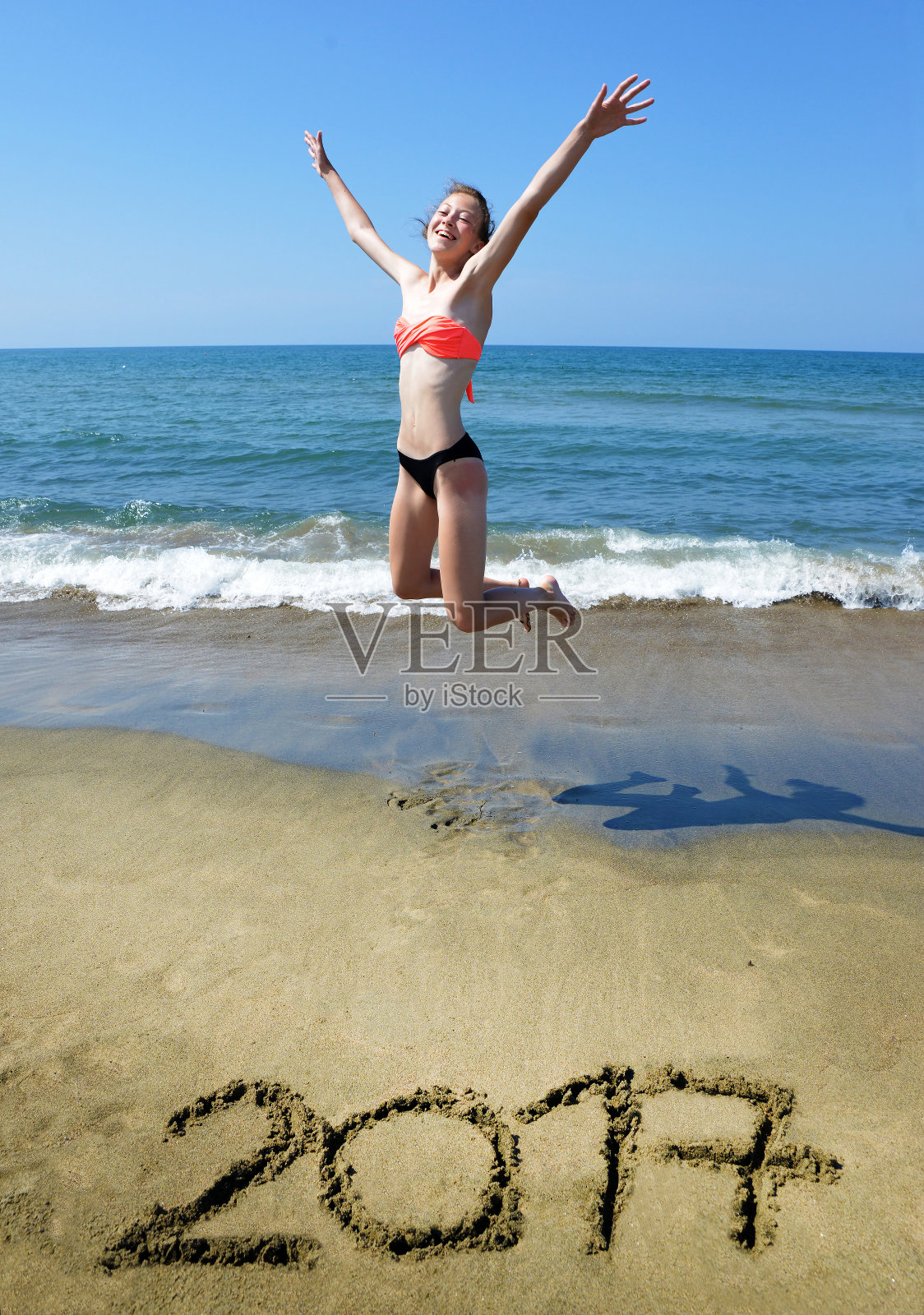 在海滩上蹦蹦跳跳的女孩照片摄影图片