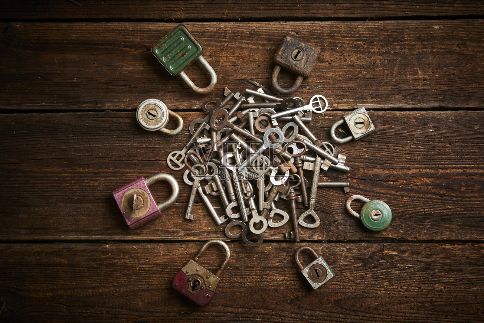 一组旧挂锁和一堆钥匙在桌子上照片摄影图片