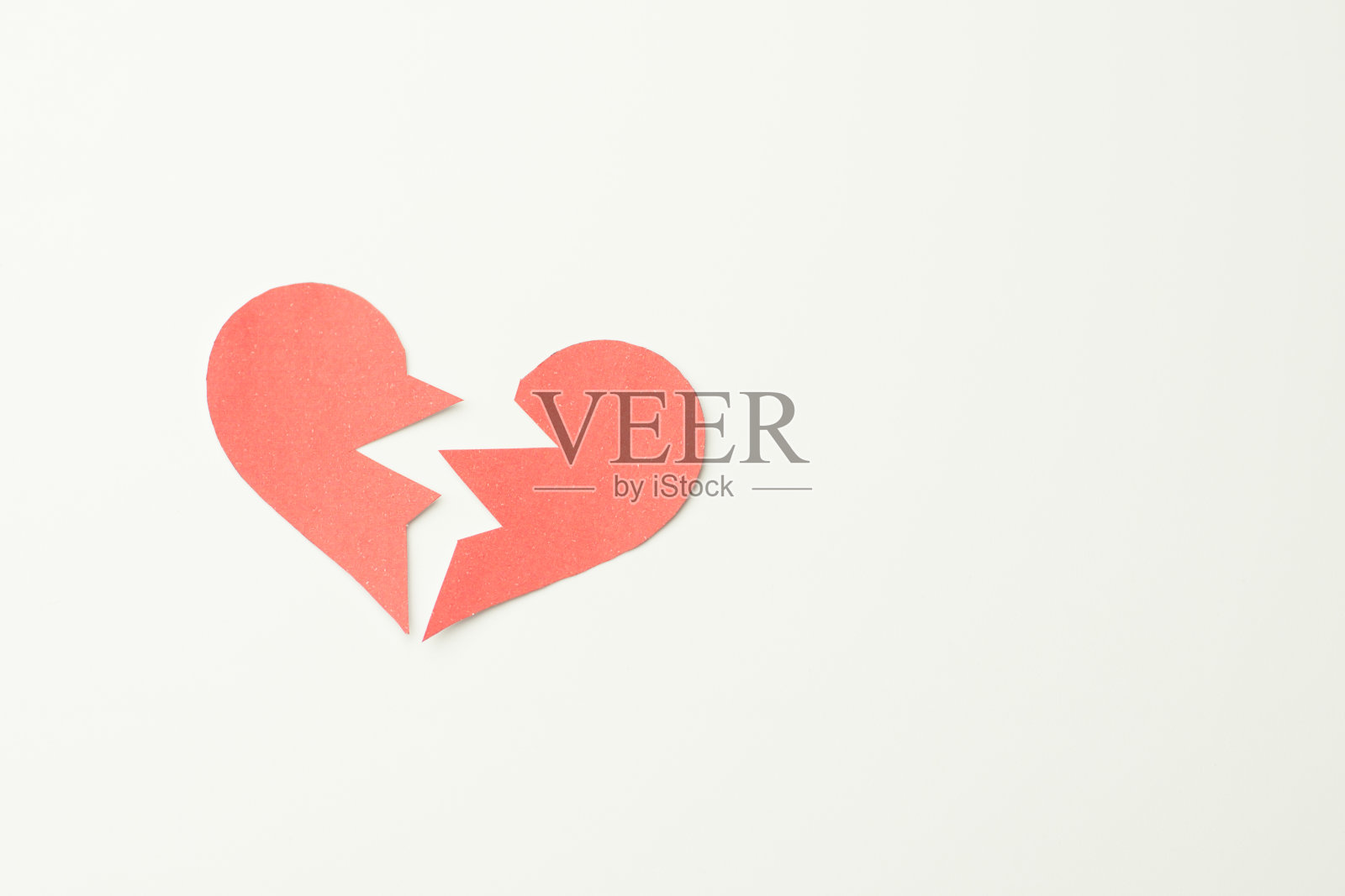 红色的纸，白色的背景，破碎的心照片摄影图片