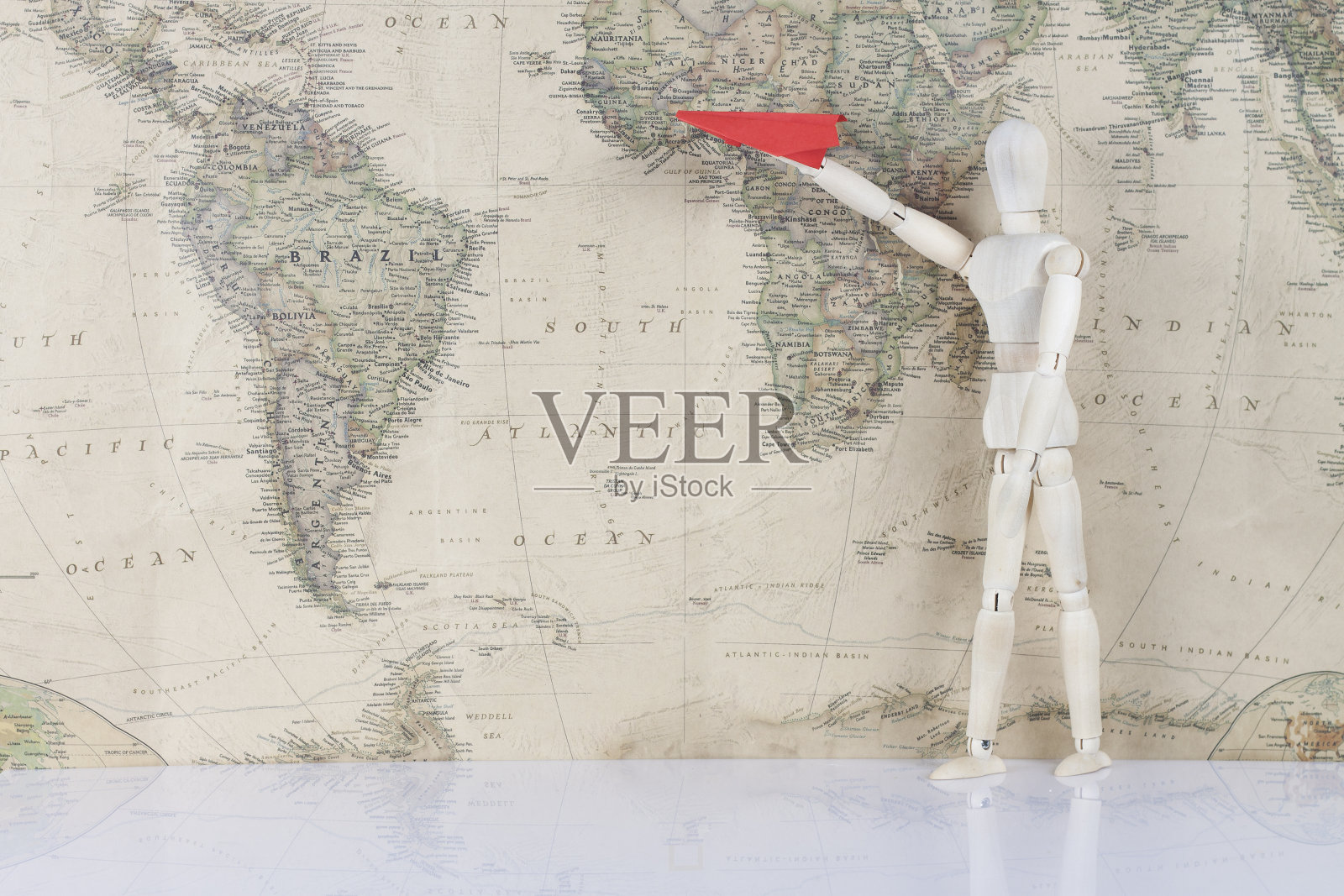 世界地图上的木头人驾驶飞机照片摄影图片