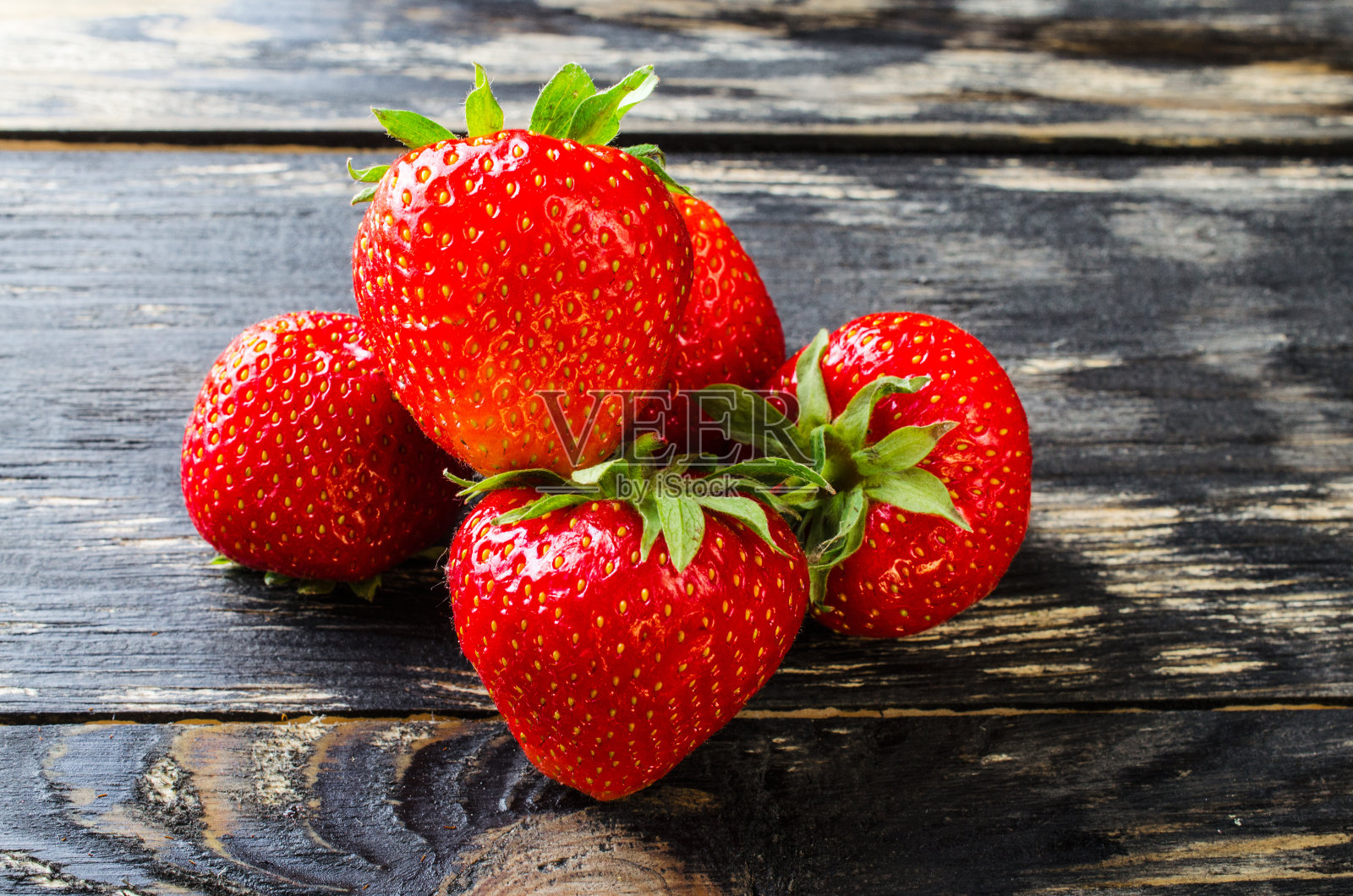 深色木质背景上的草莓。照片摄影图片