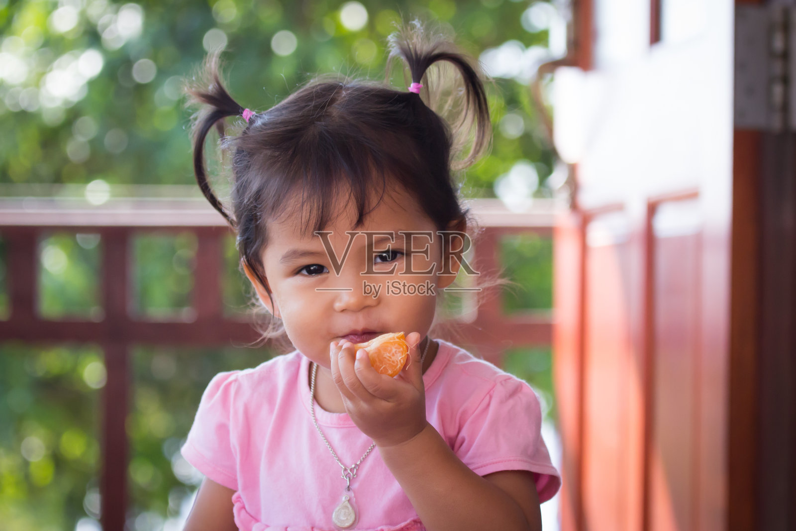 可爱的小女孩正在吃橘子照片摄影图片