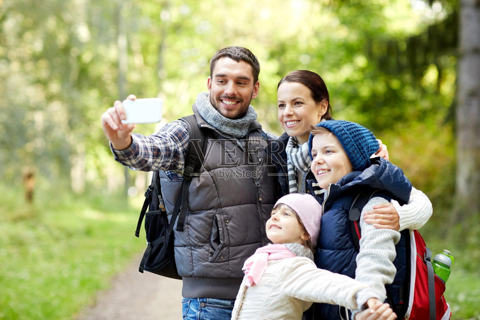 家人在树林里用智能手机自拍照片摄影图片