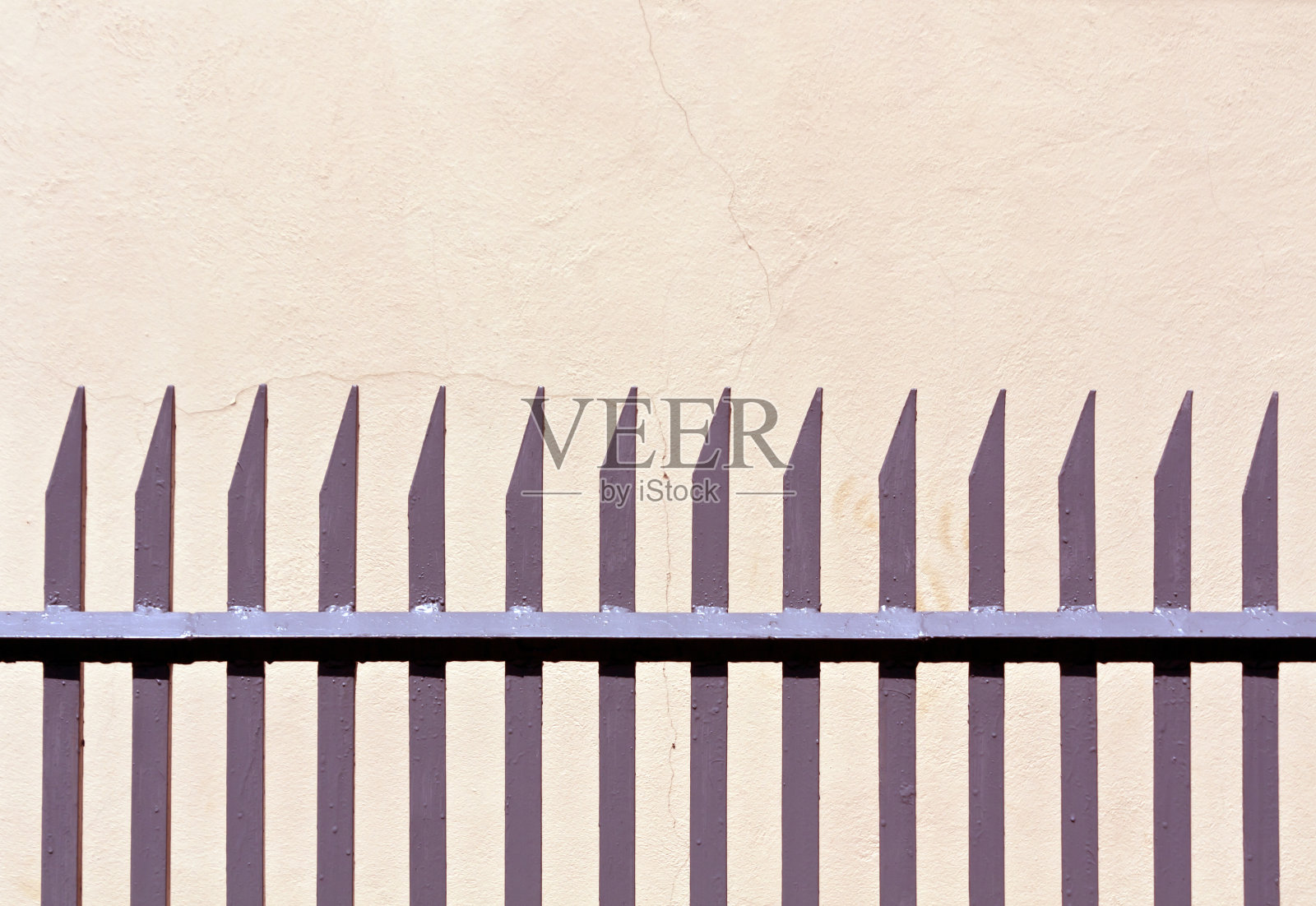 灰色的金属栅栏和灰泥墙。照片摄影图片