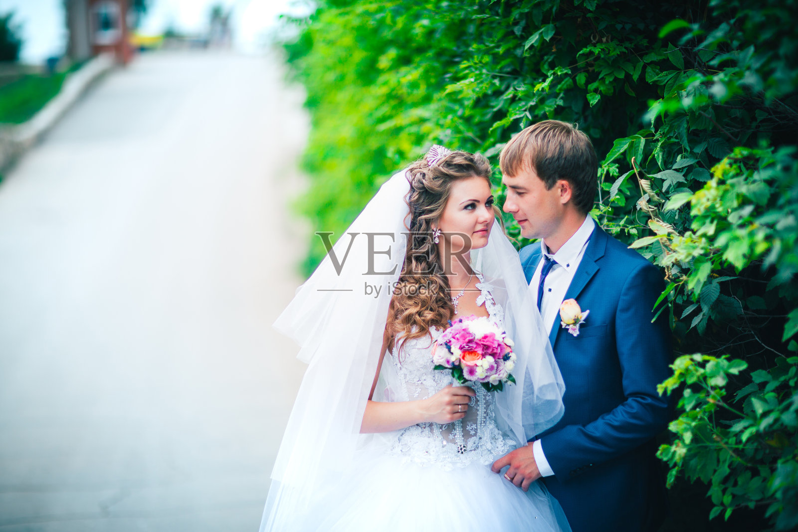 美丽的年轻夫妇摆姿势公园在树的背景照片摄影图片