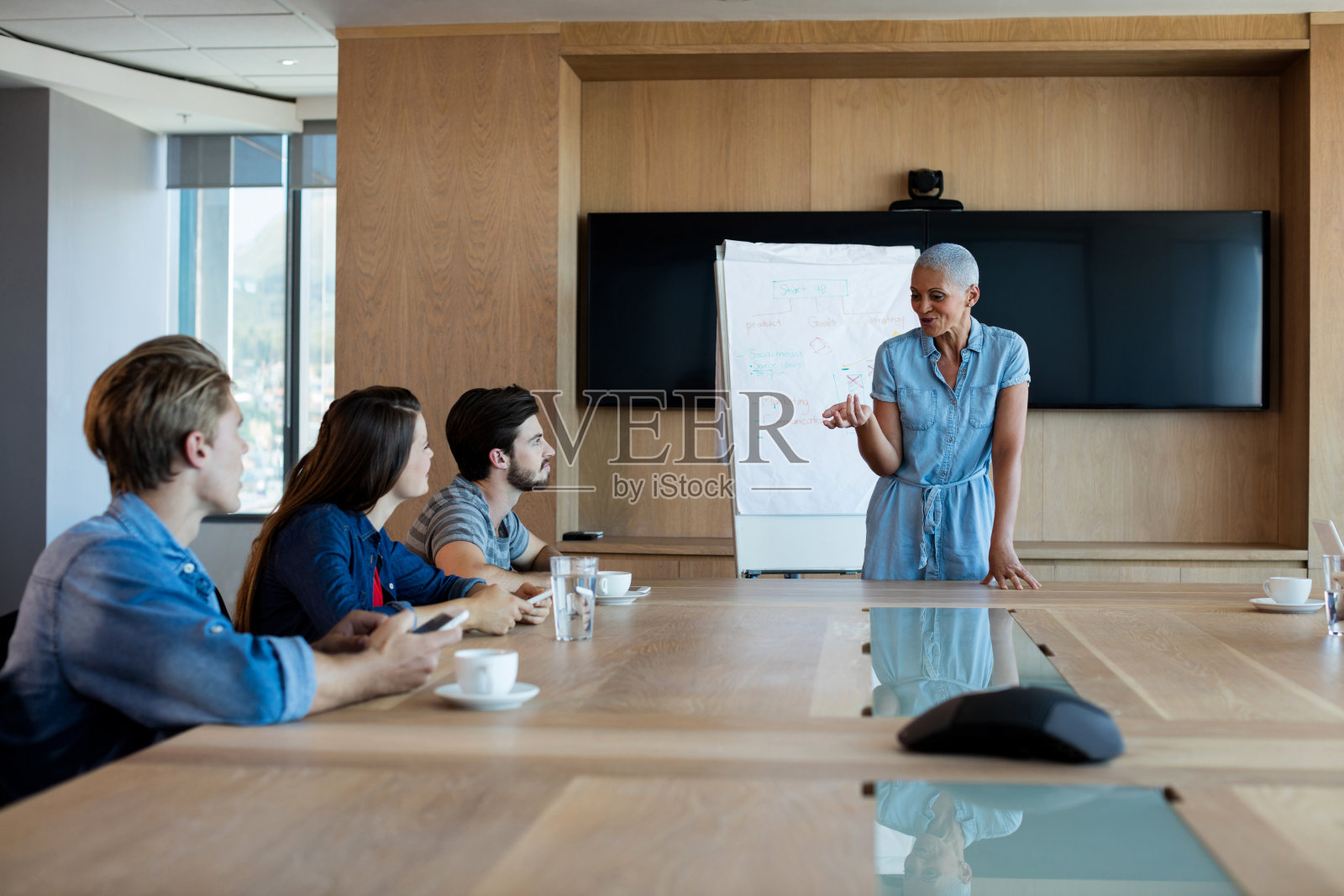 在会议室给同事做报告的女士照片摄影图片