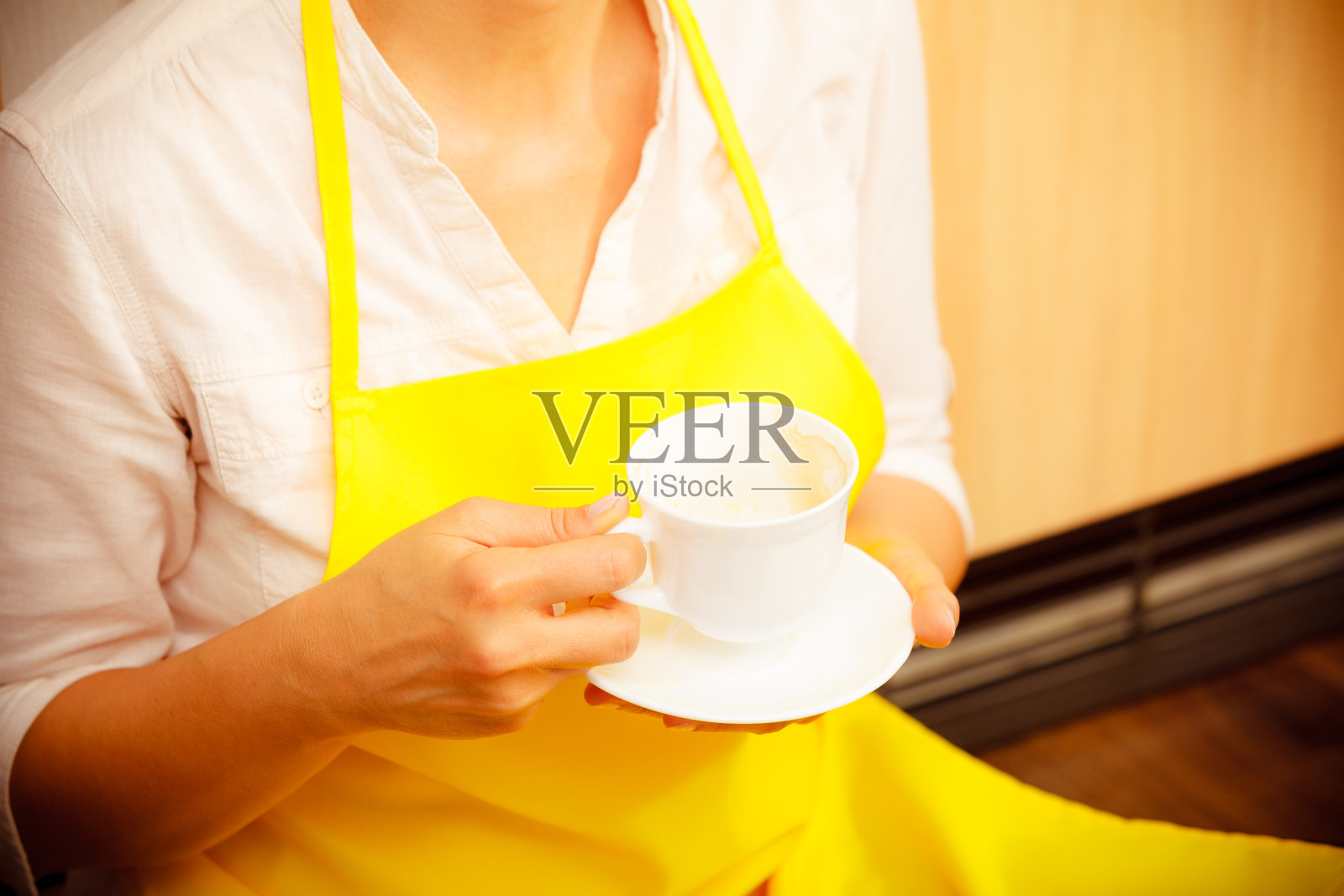 厨房里拿着咖啡的女人。照片摄影图片