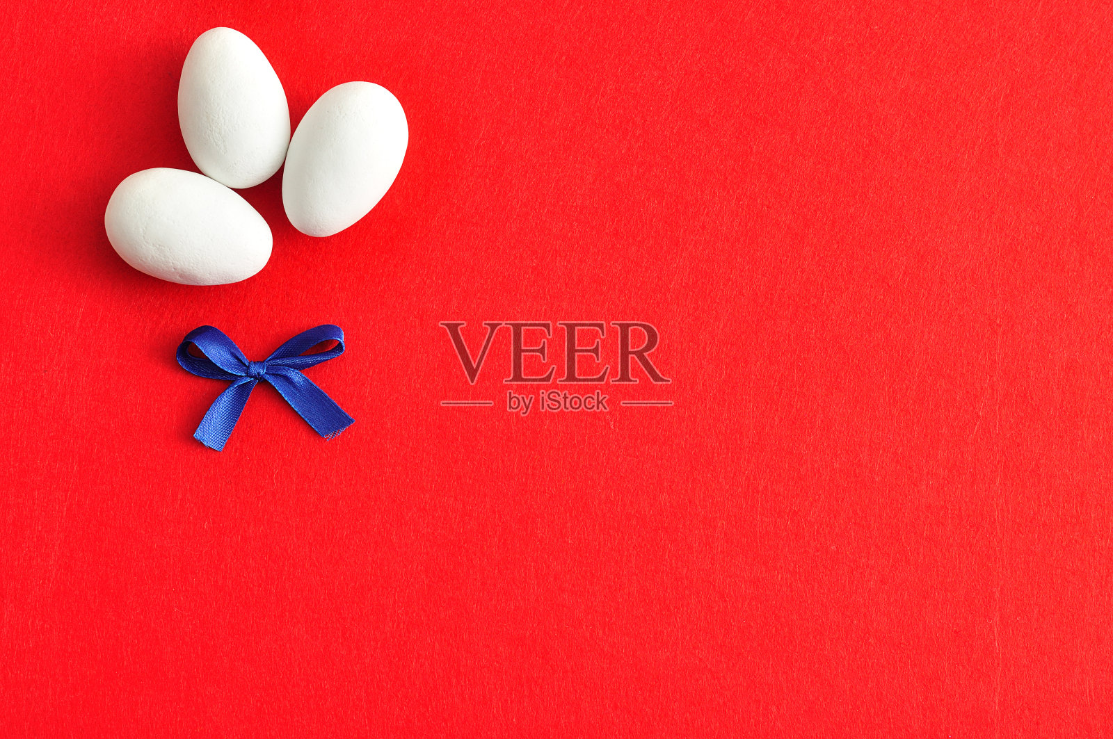 三个带着蓝色蝴蝶结的白色复活节彩蛋照片摄影图片